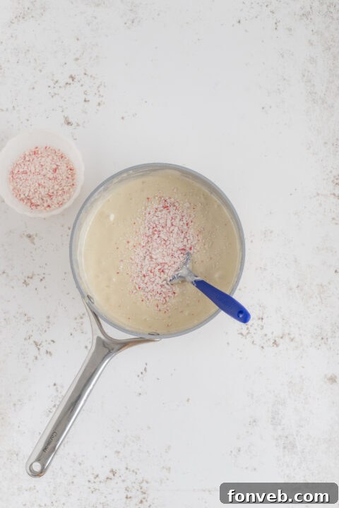 Adding mini marshmallows to the warm fudge mixture.