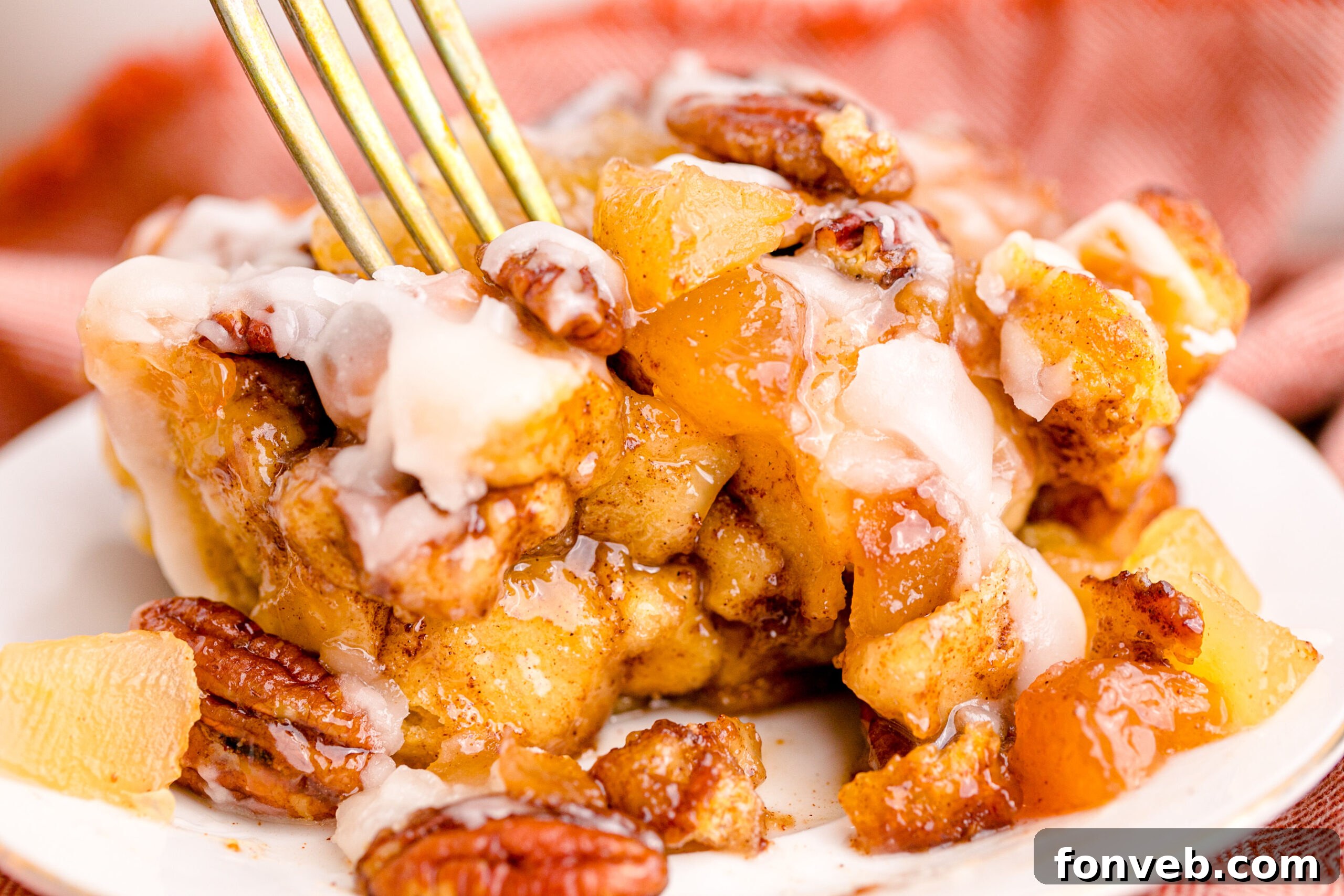 Irresistible Cinnamon Swirl Bake 13 Cinnamon Roll Casserole on a white plate with a gold fork removing a bite.