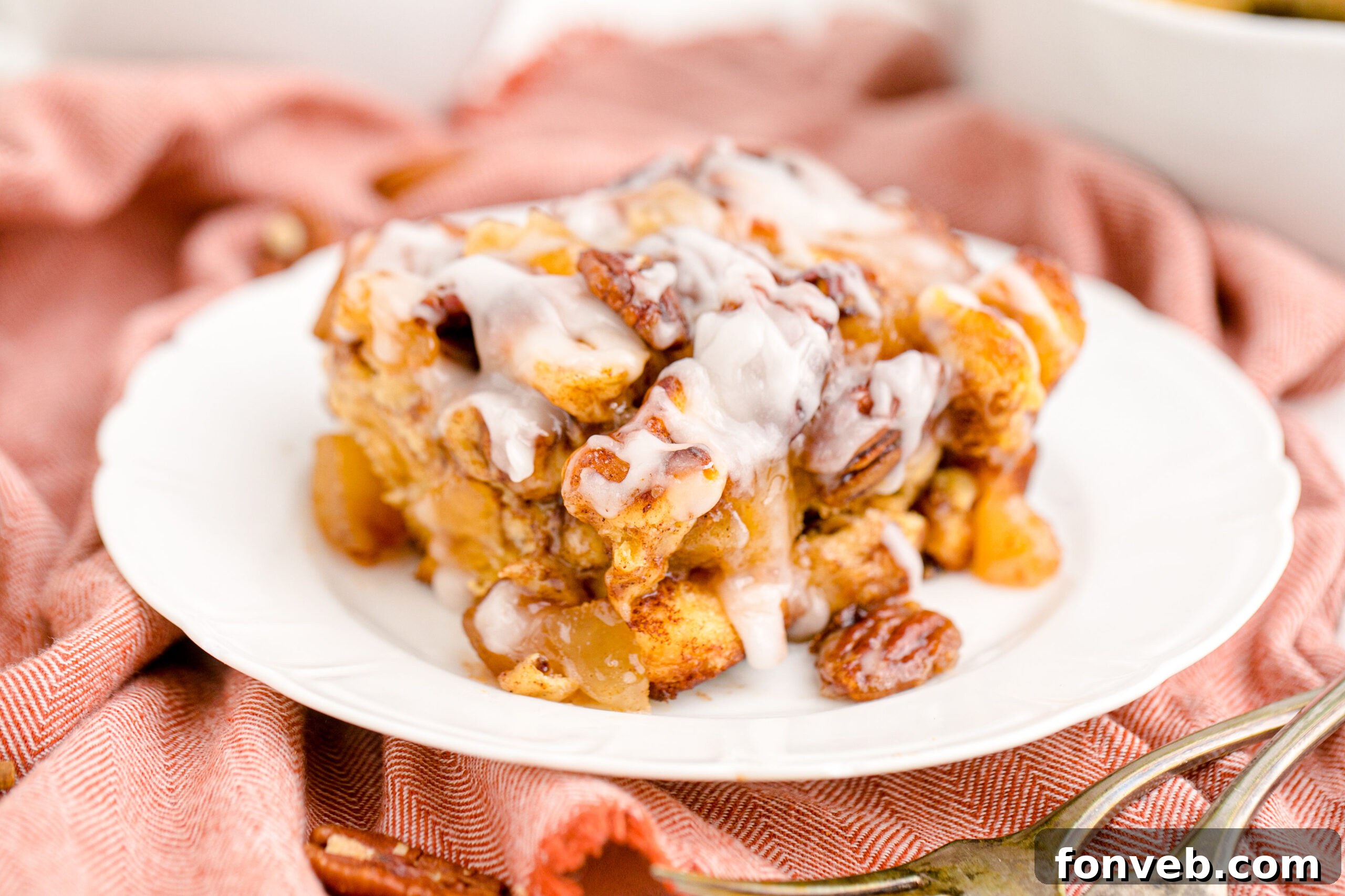 Irresistible Cinnamon Swirl Bake 18 Cinnamon Roll Casserole on a white plate covered in icing