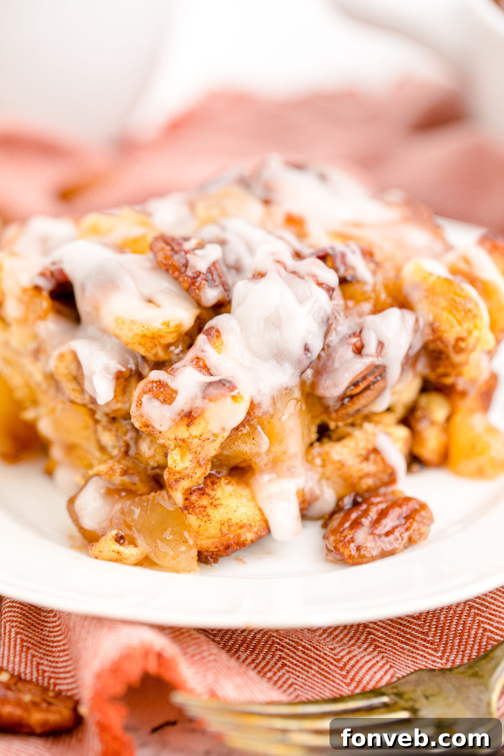 Irresistible Cinnamon Swirl Bake 5 Cinnamon Roll Casserole on a white dish topped with icing.