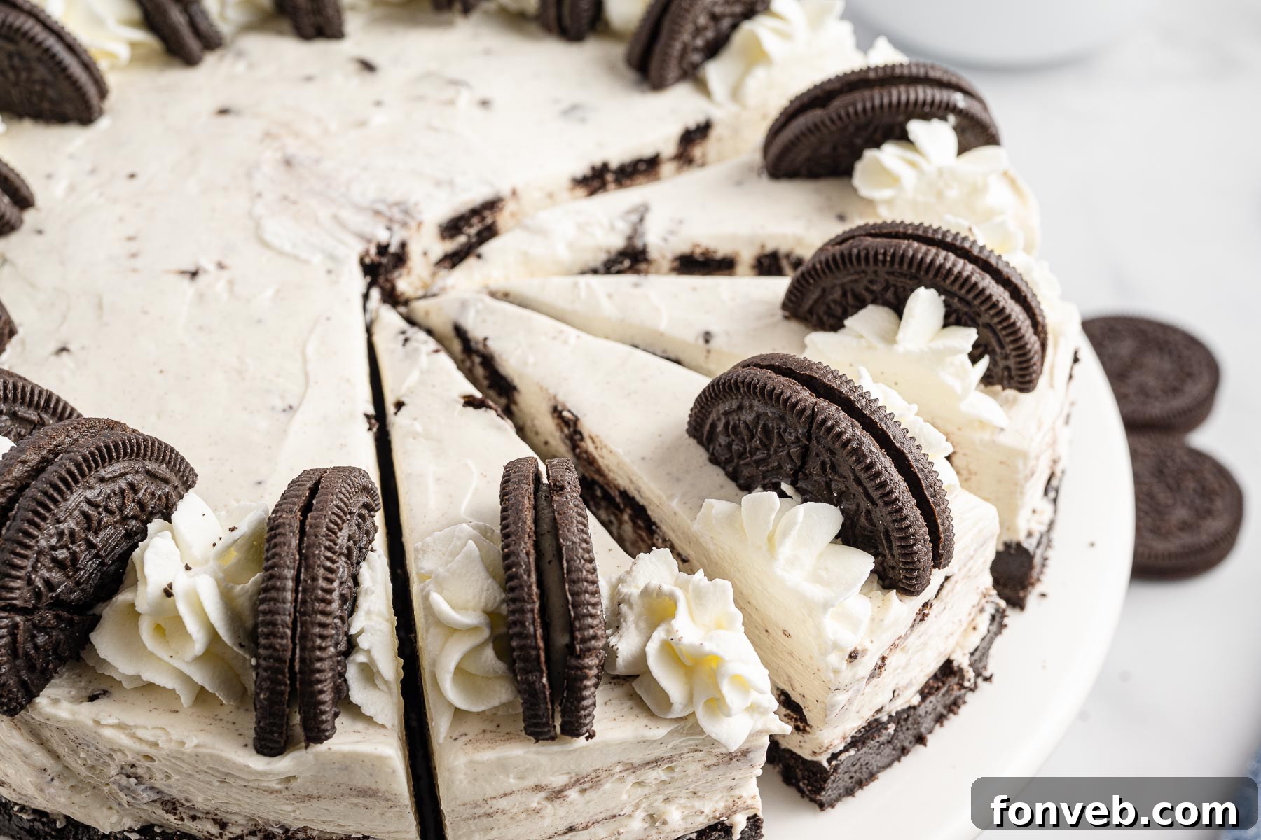 No Bake Oreo Cheesecake side view with several slices removed, showing the thick filling and dark crust.