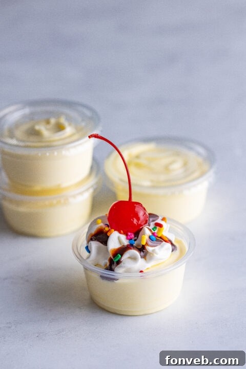 Mini Banana Split Delights 13 A hand reaching for a Banana Split Shot from a beautifully arranged platter.