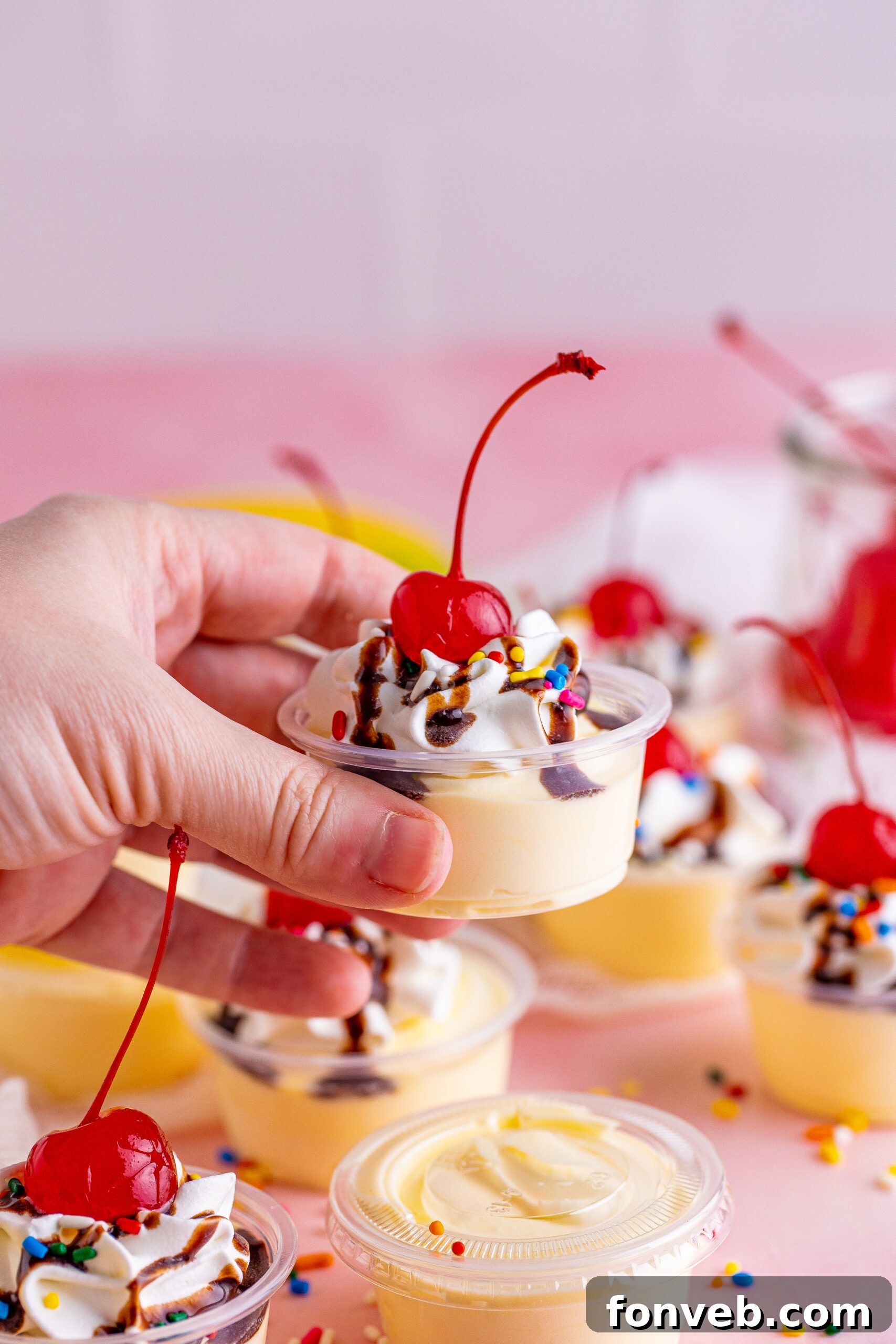 Mini Banana Split Delights 7 Side view of two Banana Split Shots being held, ready to be enjoyed.