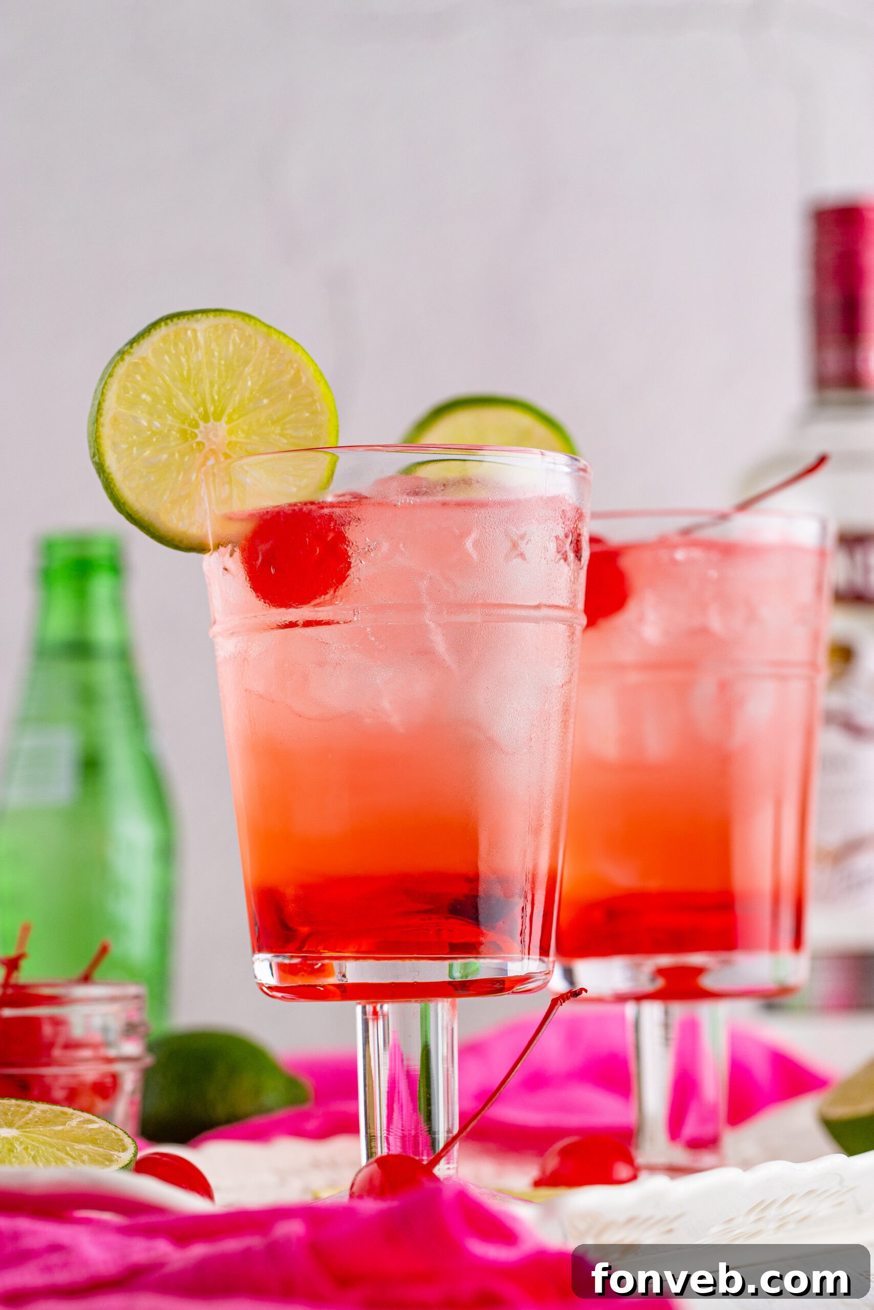 Side view of Dirty Shirley Temple garnished with a lime slice and cherry, highlighting its refreshing appeal.