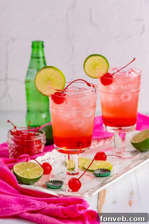 A single Dirty Shirley Temple cocktail with a lime wedge.