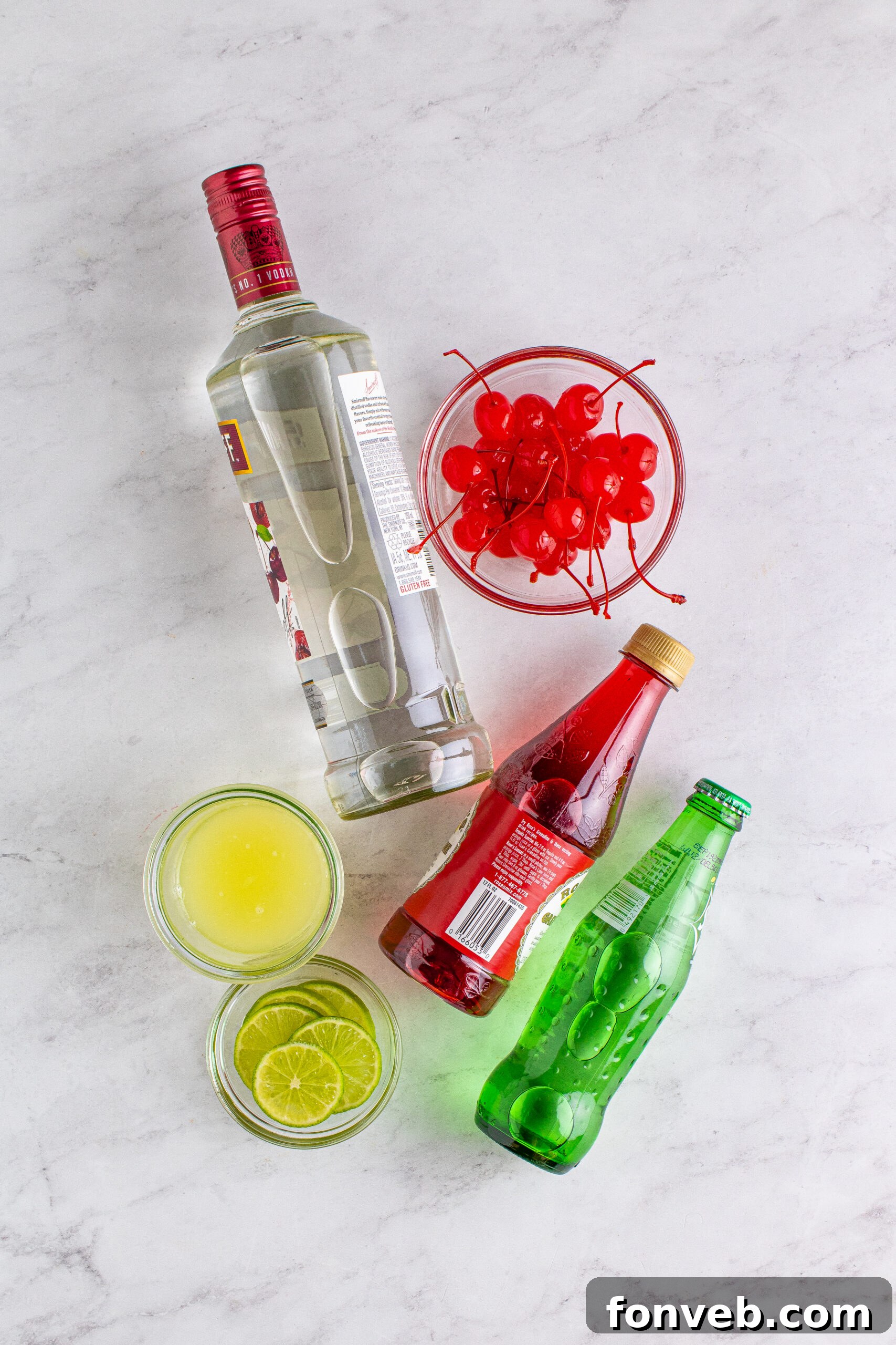 Overhead view of all the fresh and bottled ingredients laid out for the Dirty Shirley Temple recipe.