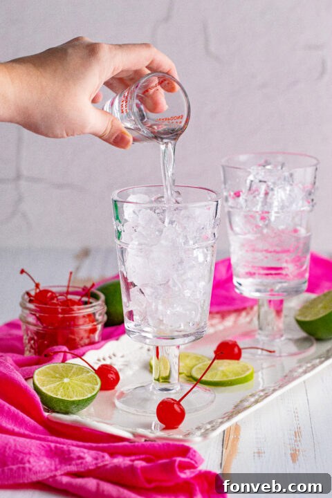 Dirty Shirley Temple in a tall glass with lime and cherry.