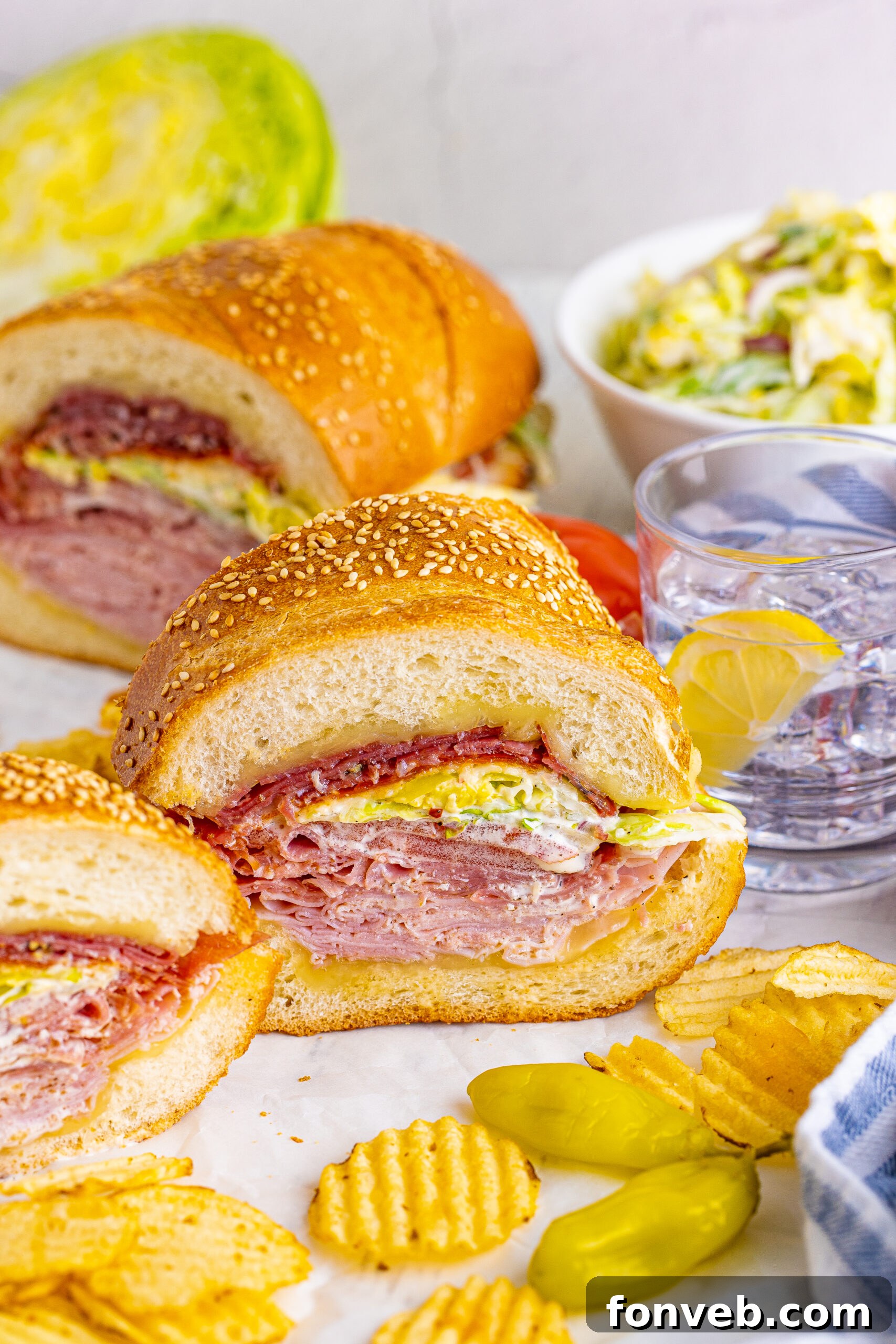 Front view of Grinder Subs on parchment paper surrounded by wavy chips.