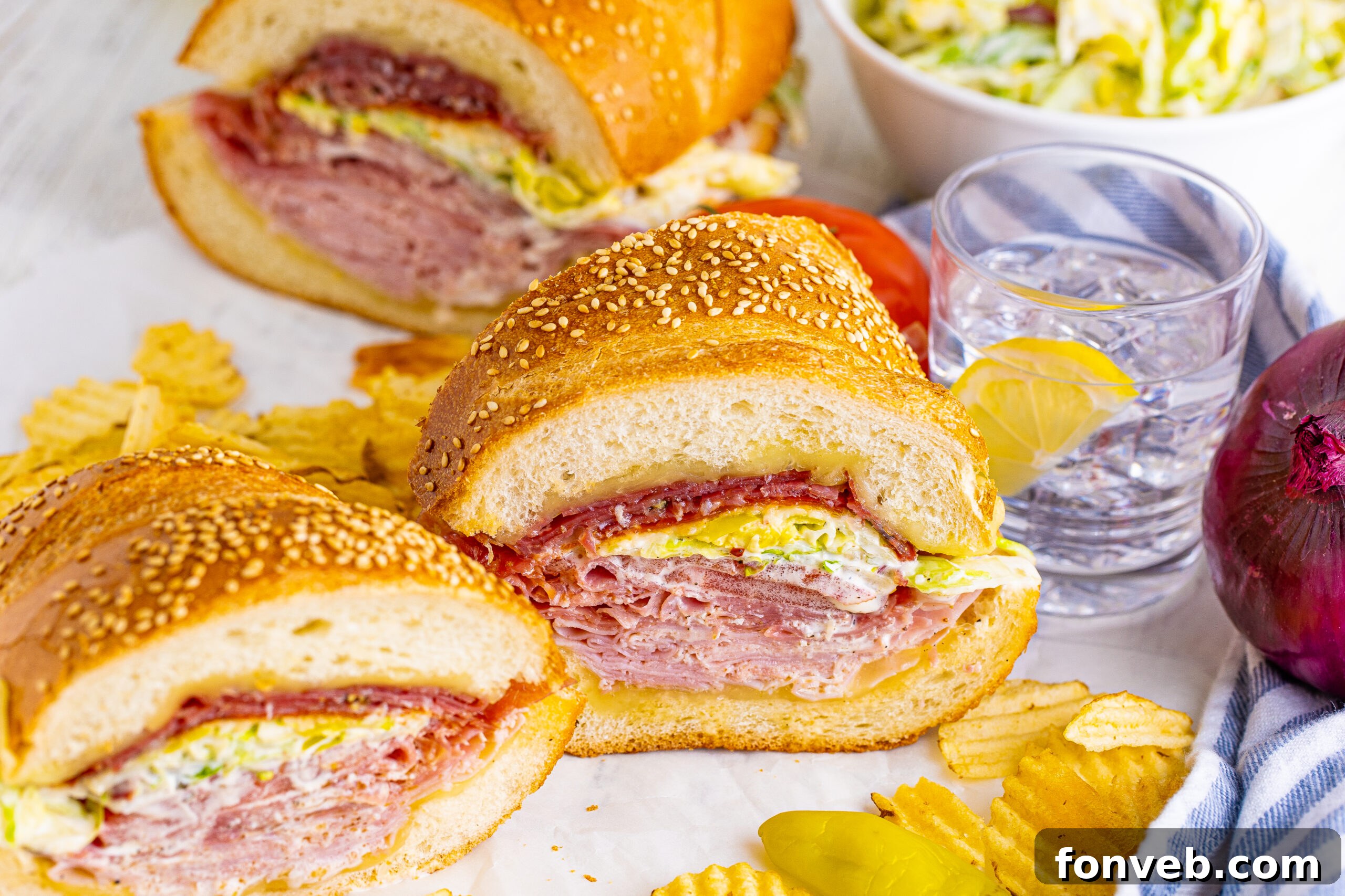 Front view of Grinder Subs on parchment paper surrounded by wavy chips.