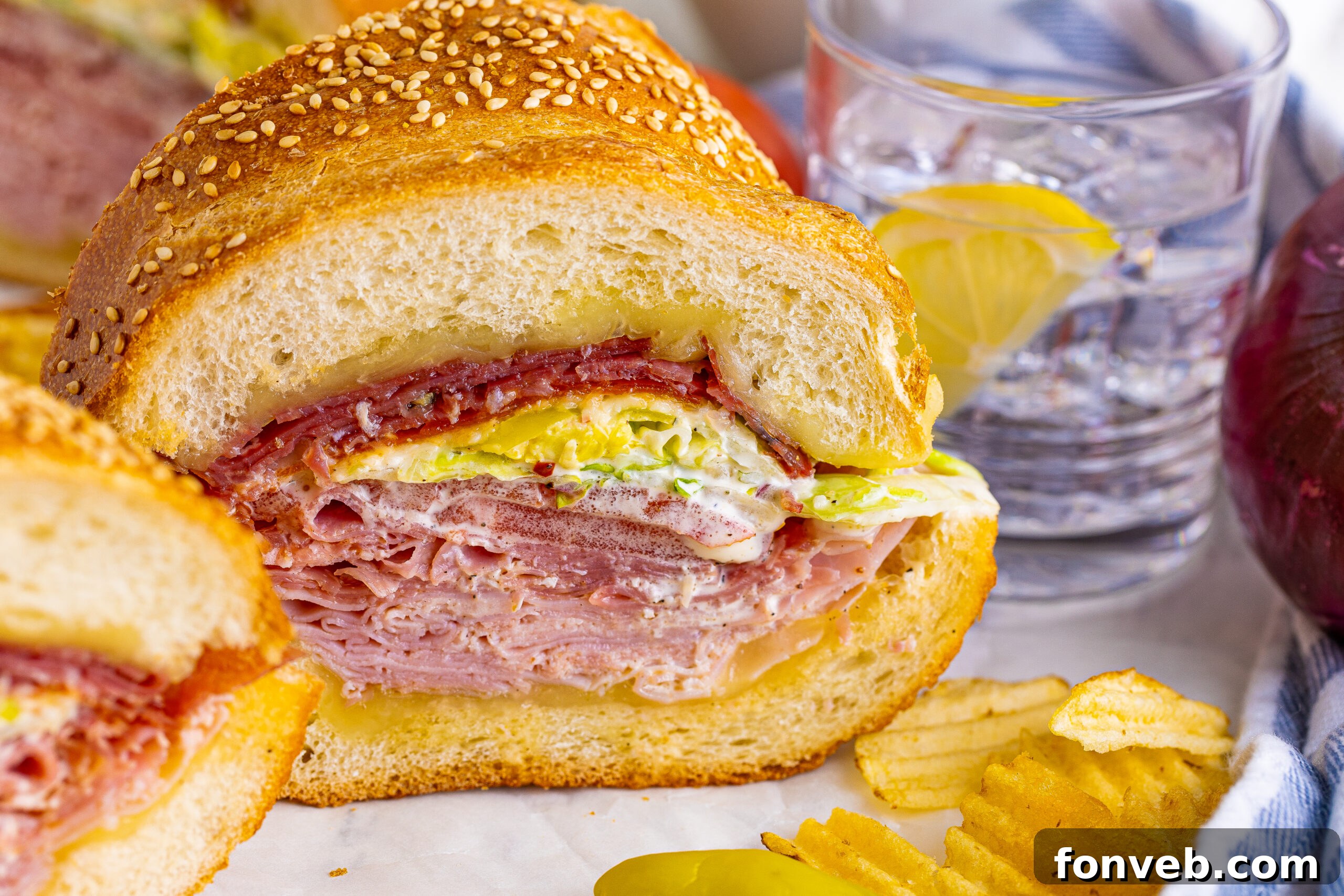Grinder sandwich close up with chips and a glass of water next to it 