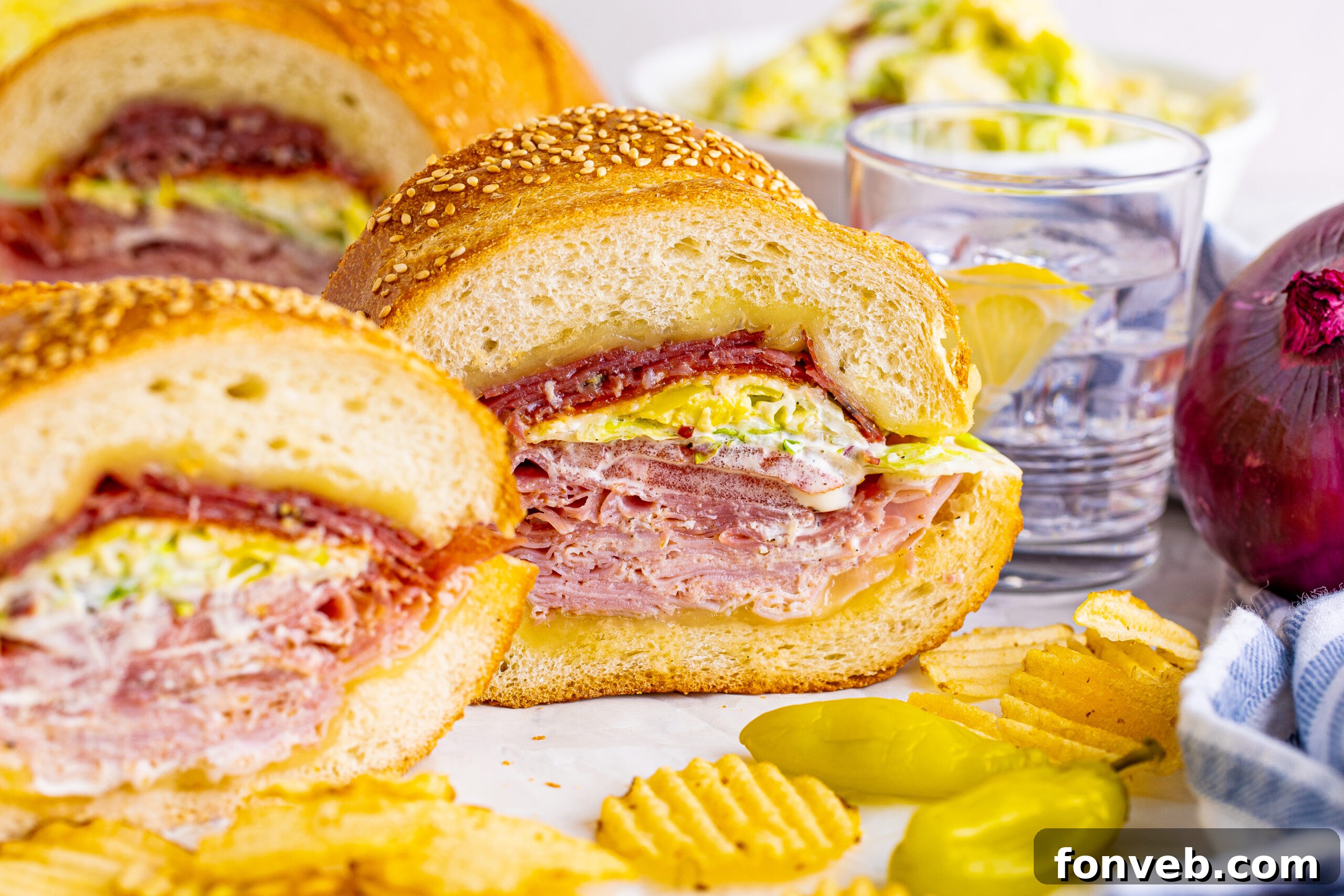 Front view of Grinder Subs on parchment paper surrounded by wavy chips.