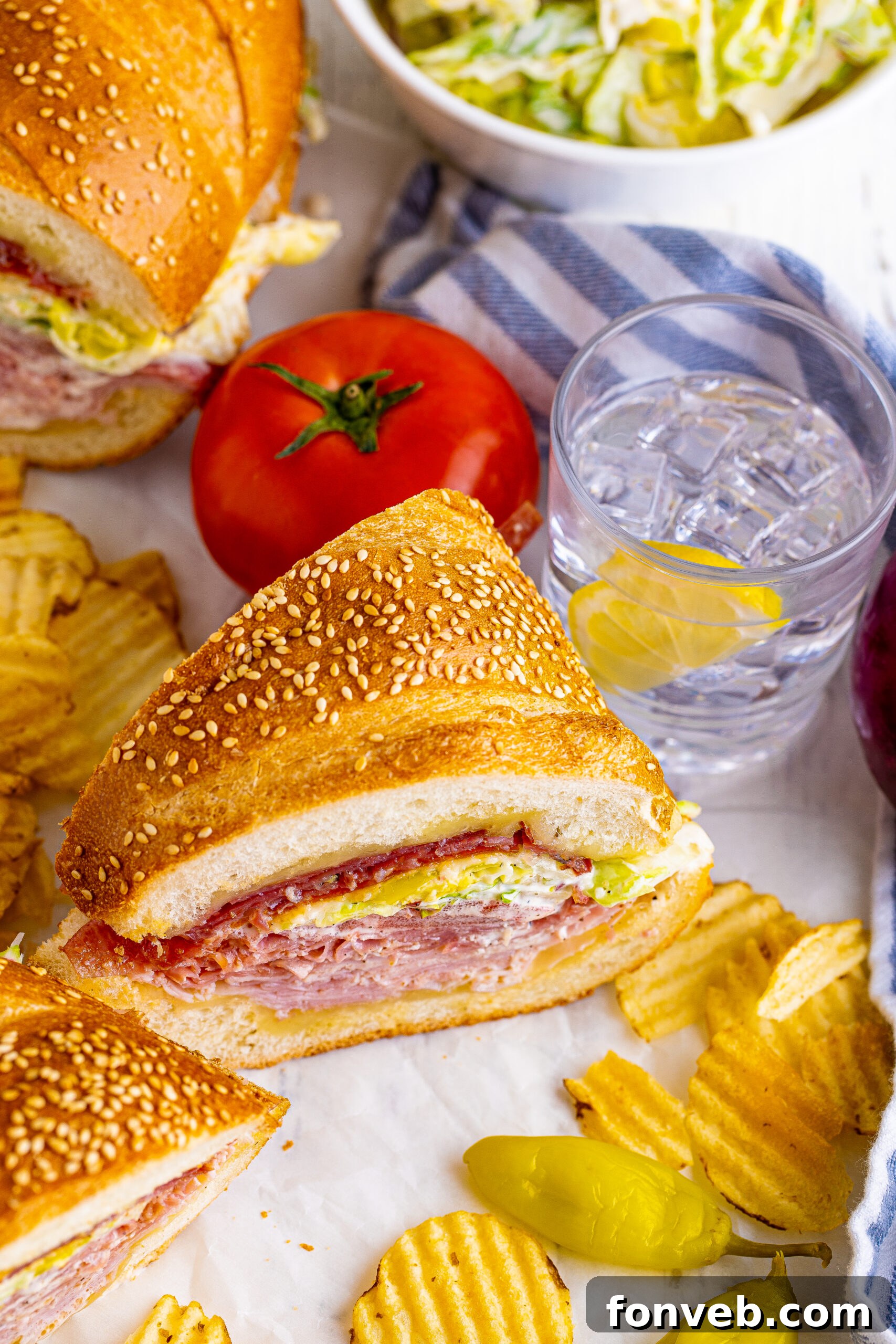 45 degree view of Grinder Subs on parchment paper surrounded by wavy chips. 