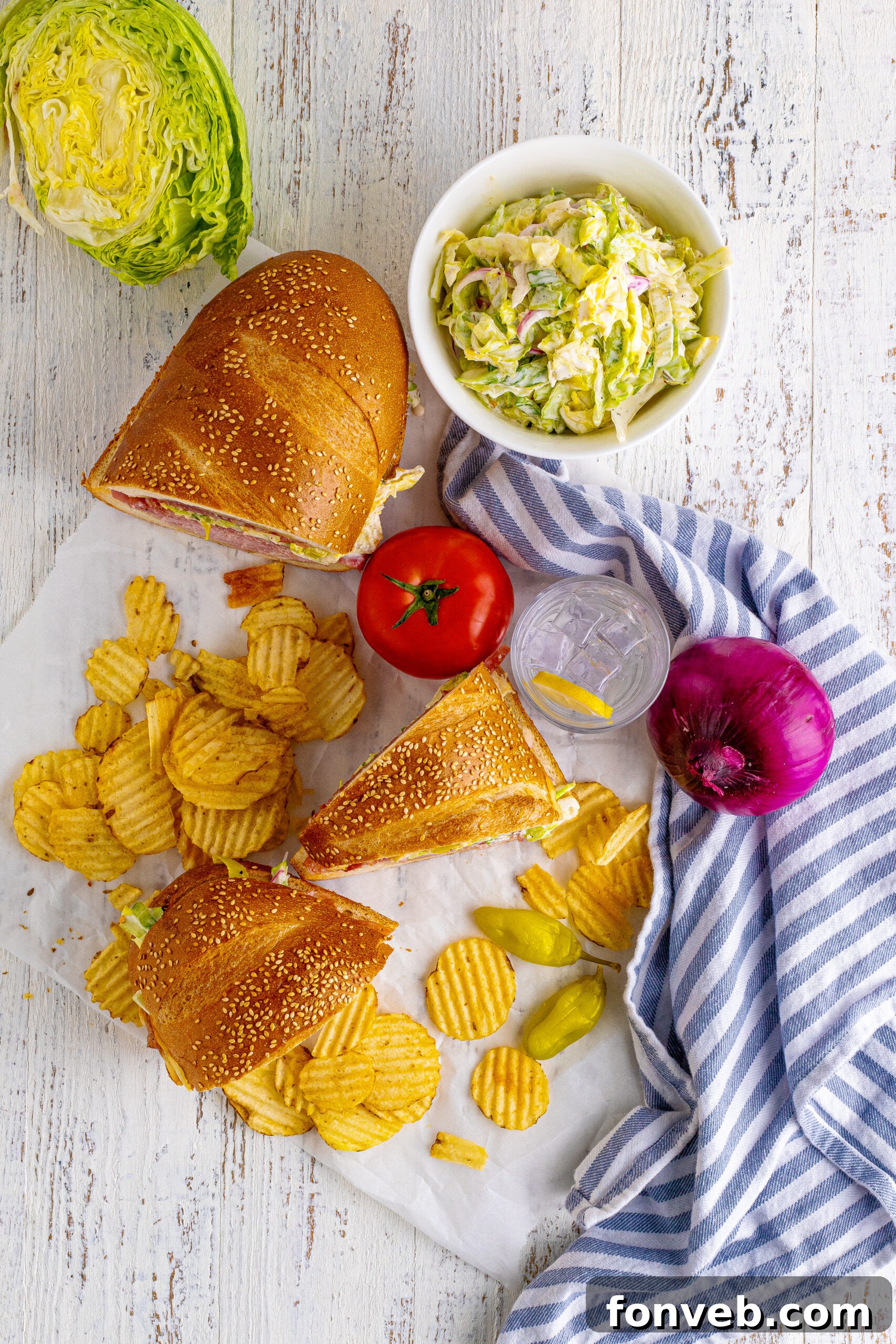 Overhead view of Grinder Subs on a piece of parchment paper surrounded with wavy chips.