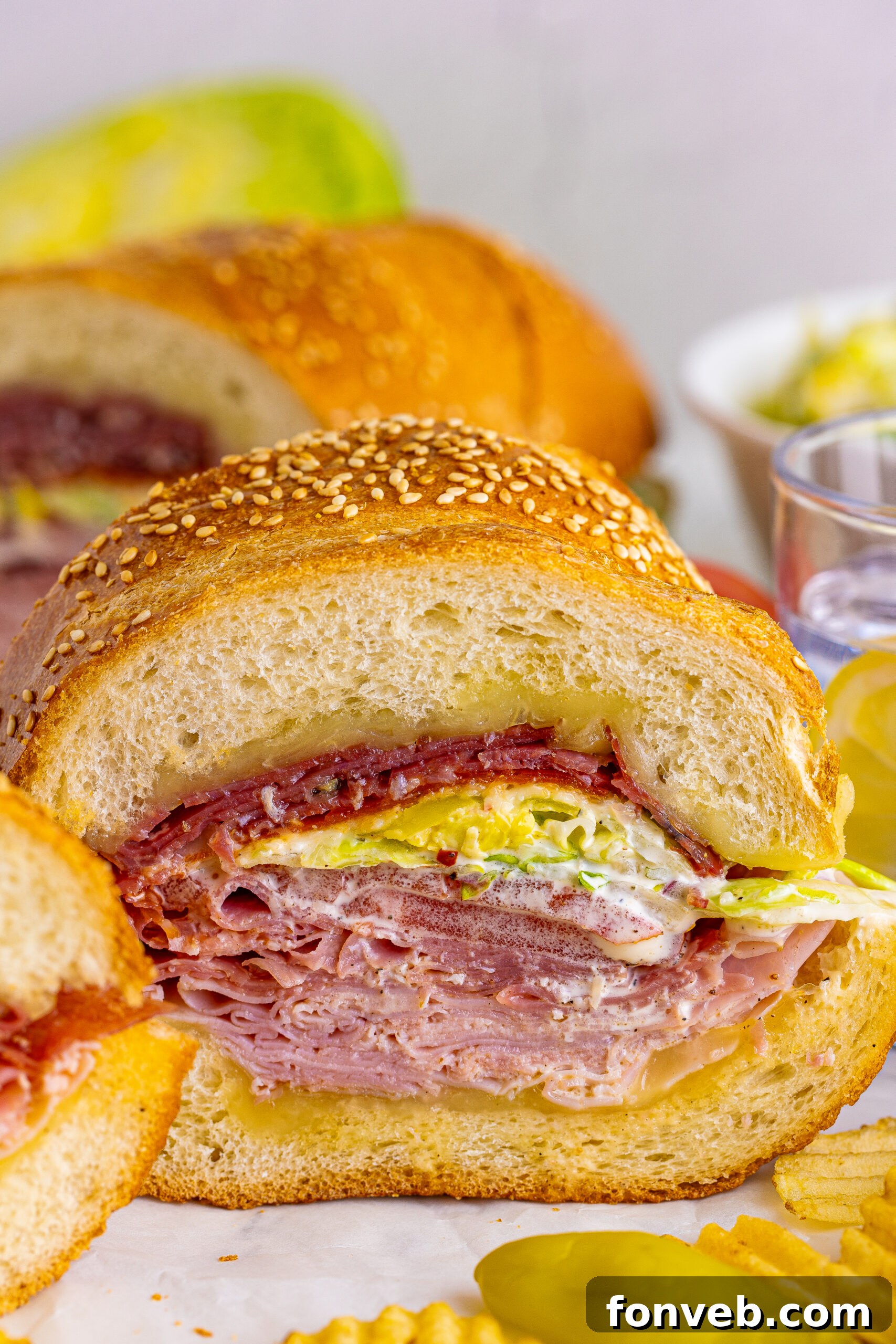 Front view of Grinder Subs on parchment paper surrounded by wavy chips.