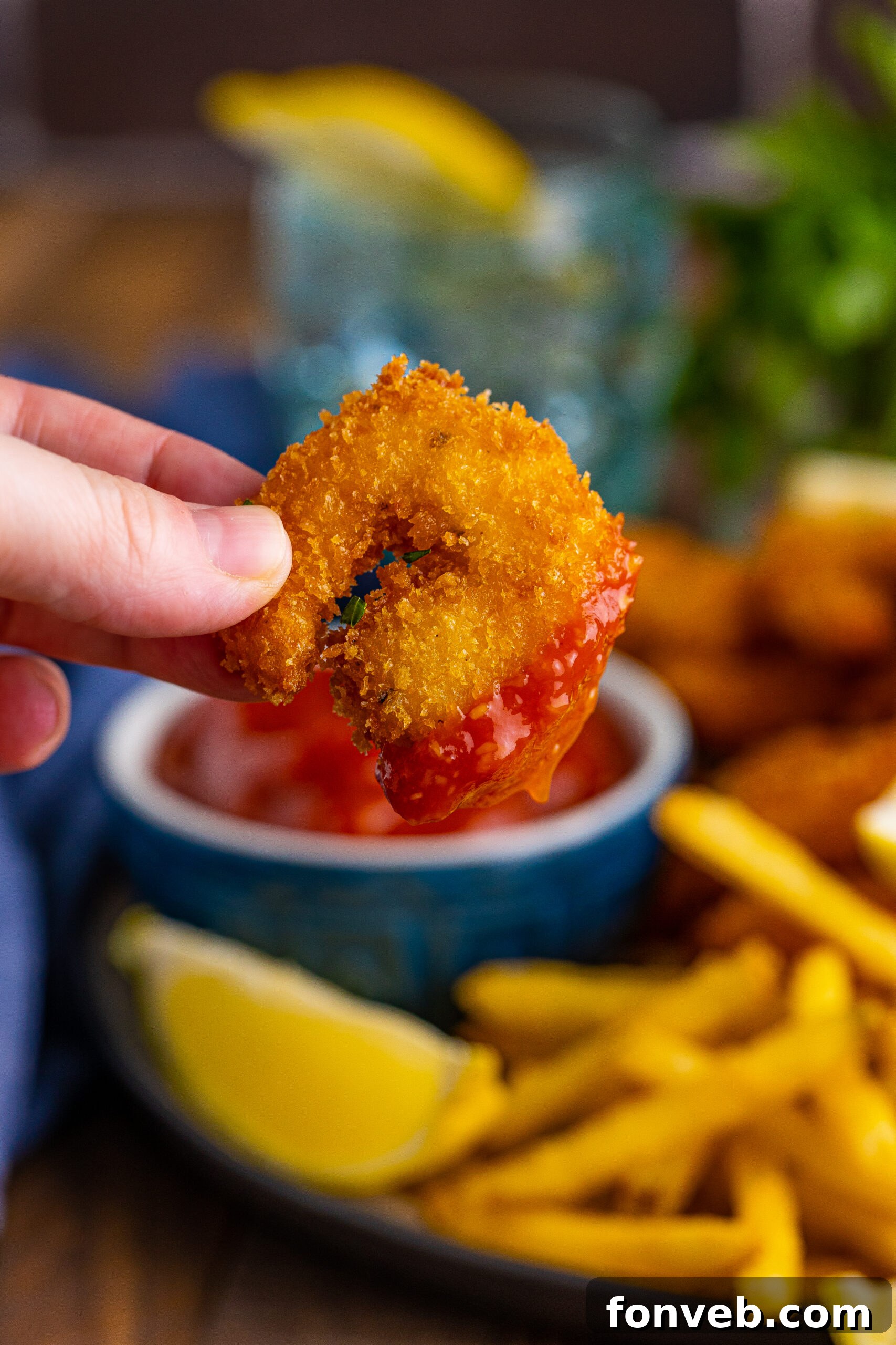 Close up view of Panko Fried Shrimp with the tip covered in cocktail sauce.