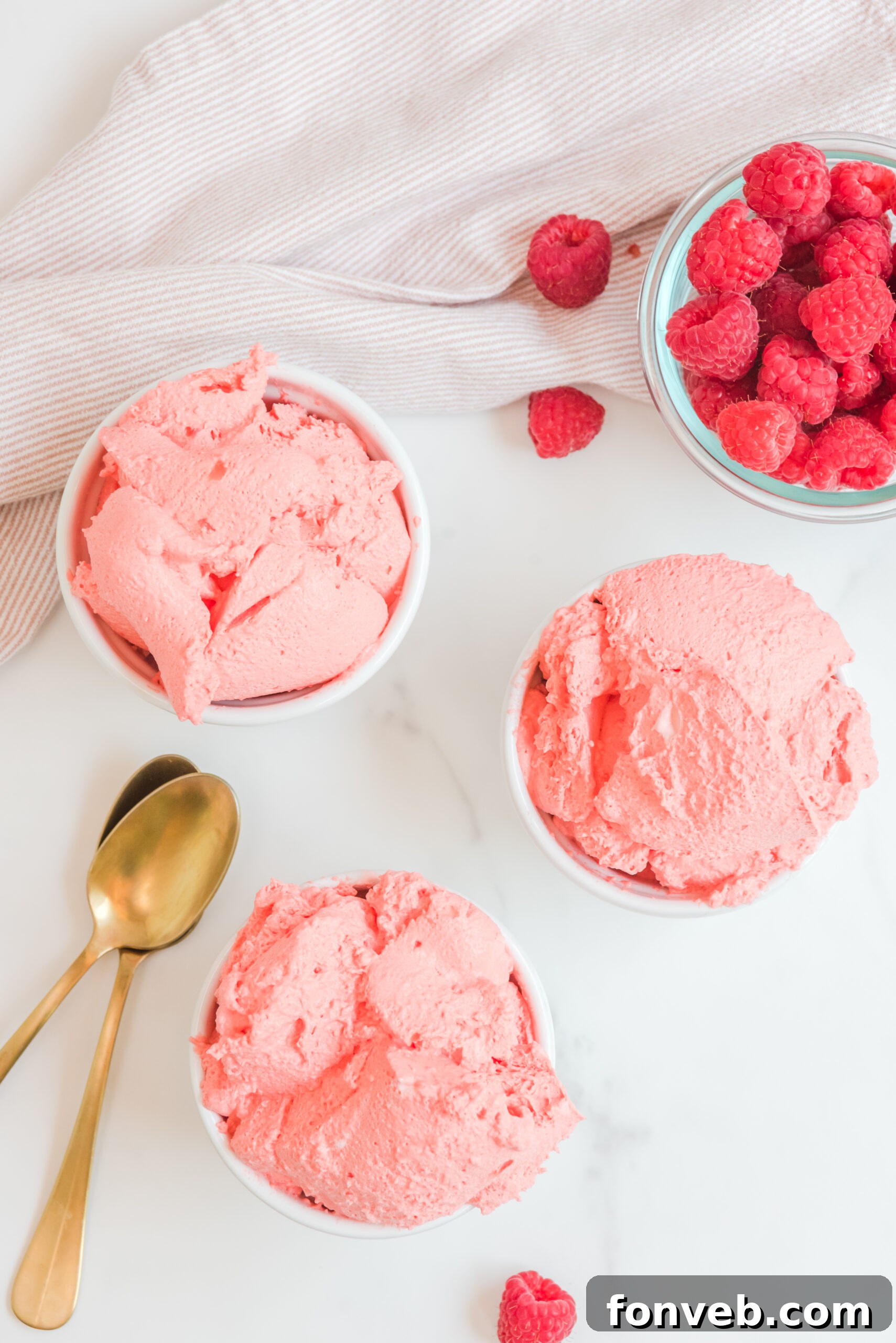 Luscious Raspberry Whip 5 Overhead view of Raspberry Jello Fluff in three elegant white dishes, garnished for serving.