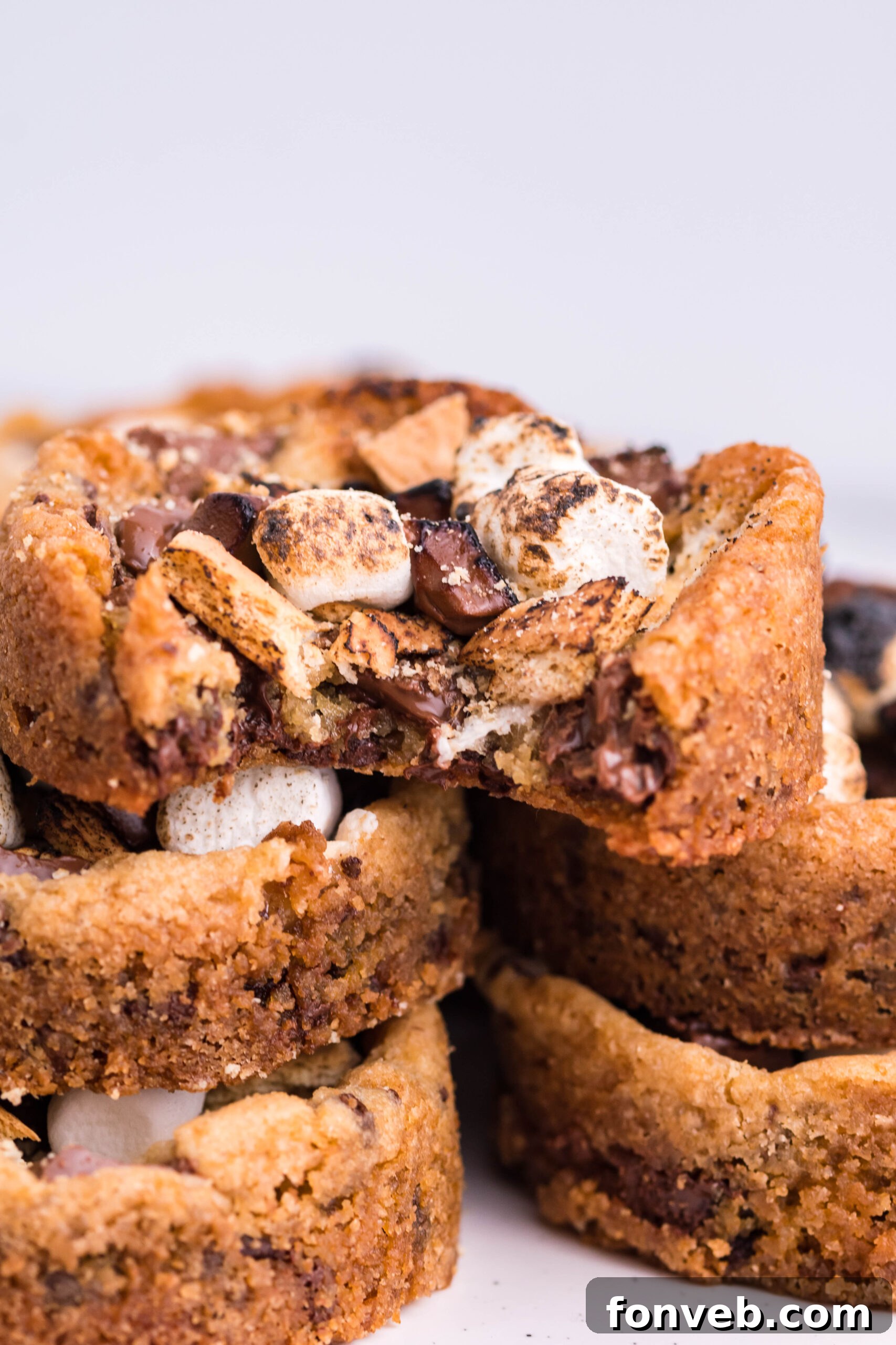 Front view of five Deep Dish S’mores Cookies staked with a bite removed from the top cookie.