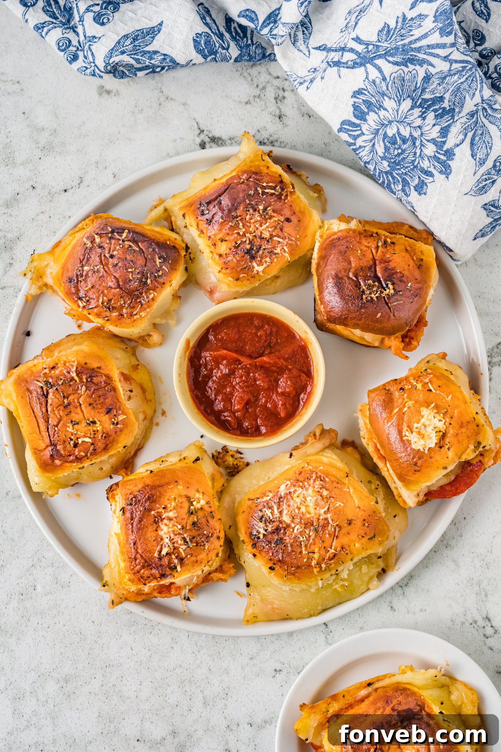 Ultimate Pizza Pull-Aparts 17 A full platter of delicious pepperoni pizza sliders with a bowl of marinara sauce in the center, ready for a party.