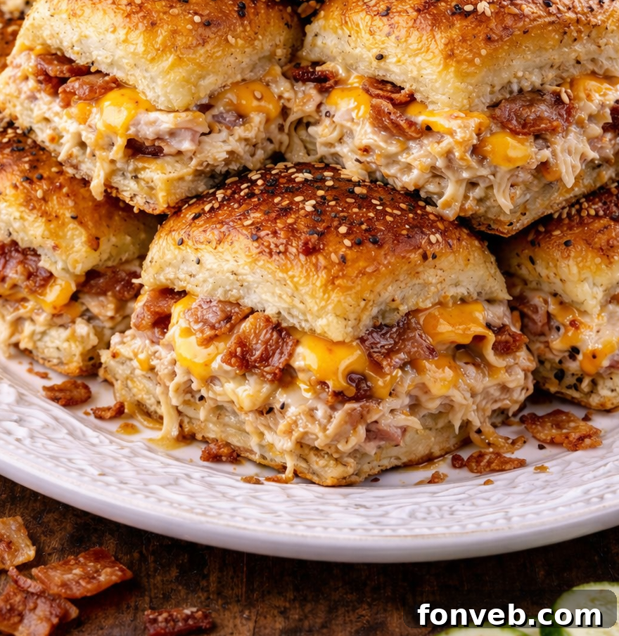Front up close view of three Crack Chicken Sliders stacked on a white plate.