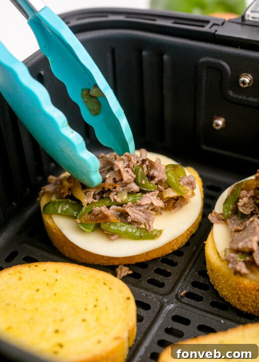 Golden Air Fryer Philly Cheesesteaks 11 Texas toast slices arranged in an air fryer basket.