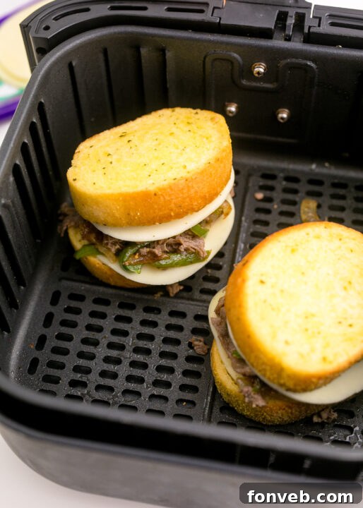 Golden Air Fryer Philly Cheesesteaks 12 Assembling a Philly cheesesteak with provolone cheese on Texas toast.
