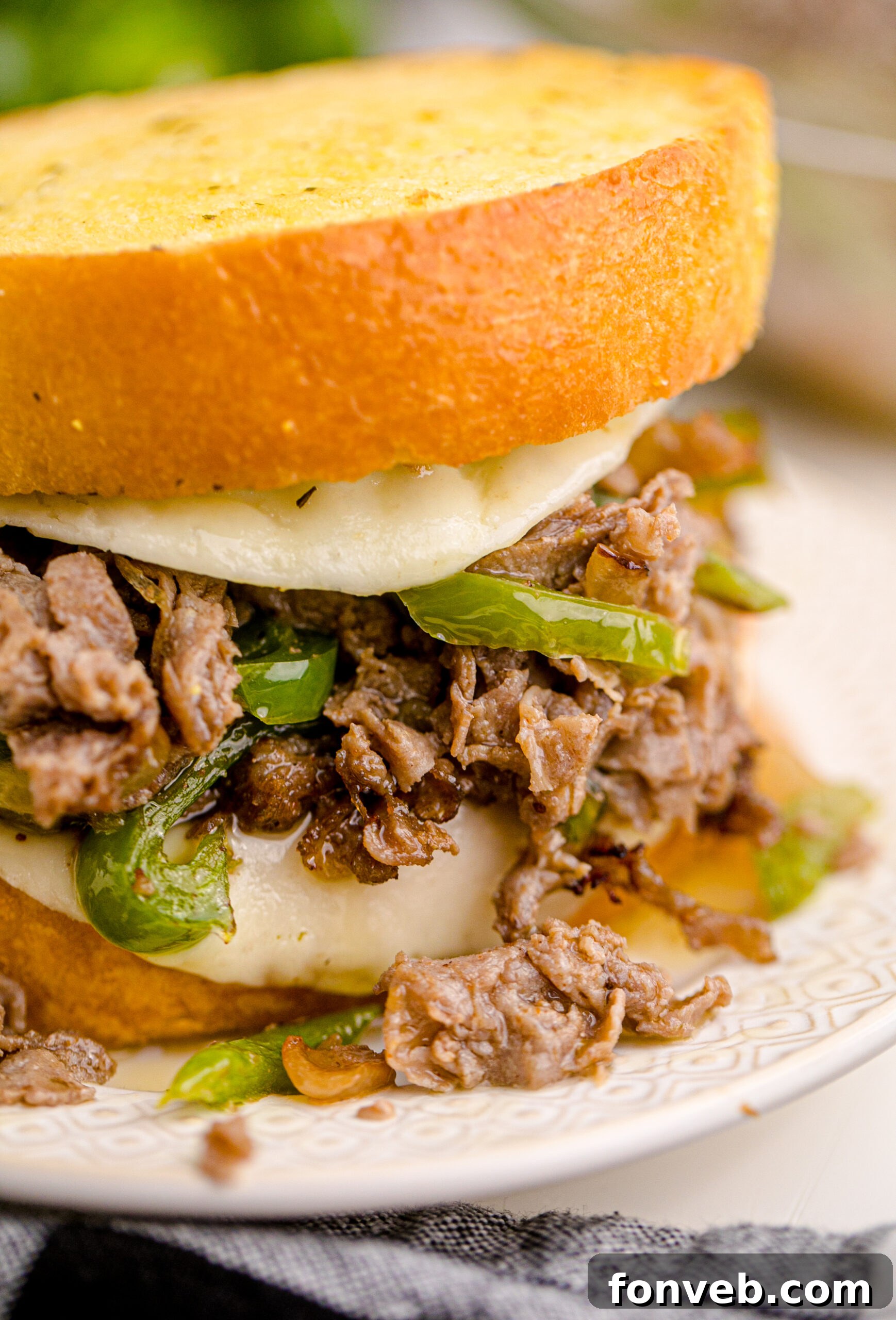 Golden Air Fryer Philly Cheesesteaks 4 Up close view of a perfectly assembled Air Fryer Philly Cheese Steak on a white plate, ready to eat.