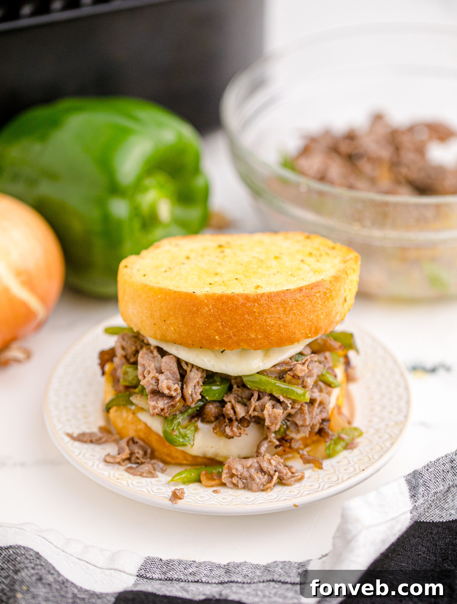 Golden Air Fryer Philly Cheesesteaks 5 Front view of two Air Fryer Philly Cheese Steaks on a white plate, highlighting the golden-brown Texas toast.