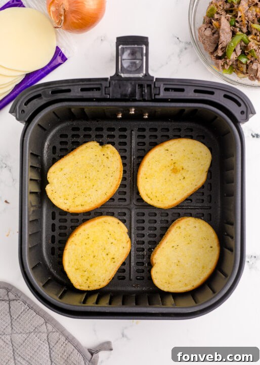 Golden Air Fryer Philly Cheesesteaks 10 Sautéed vegetables being added back to the cooked steak.