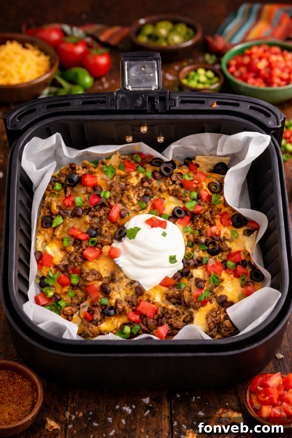 Ultimate Air Fryer Nachos 2 Overhead view of Air Fryer Nachos in an air fryer basket.