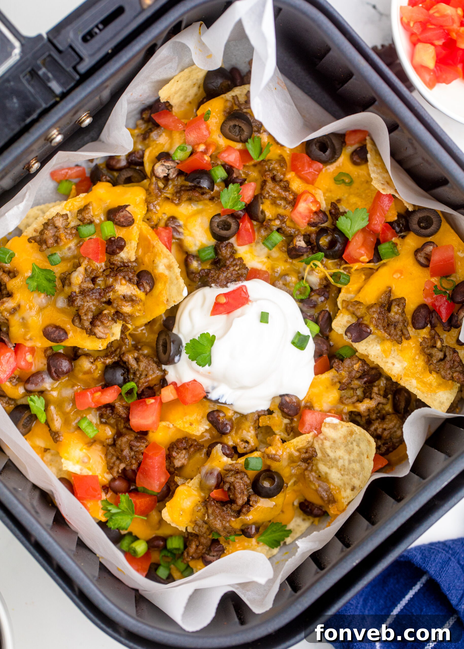 Ultimate Air Fryer Nachos 7 Overhead view of Air Fryer Nachos in an air fryer basket.