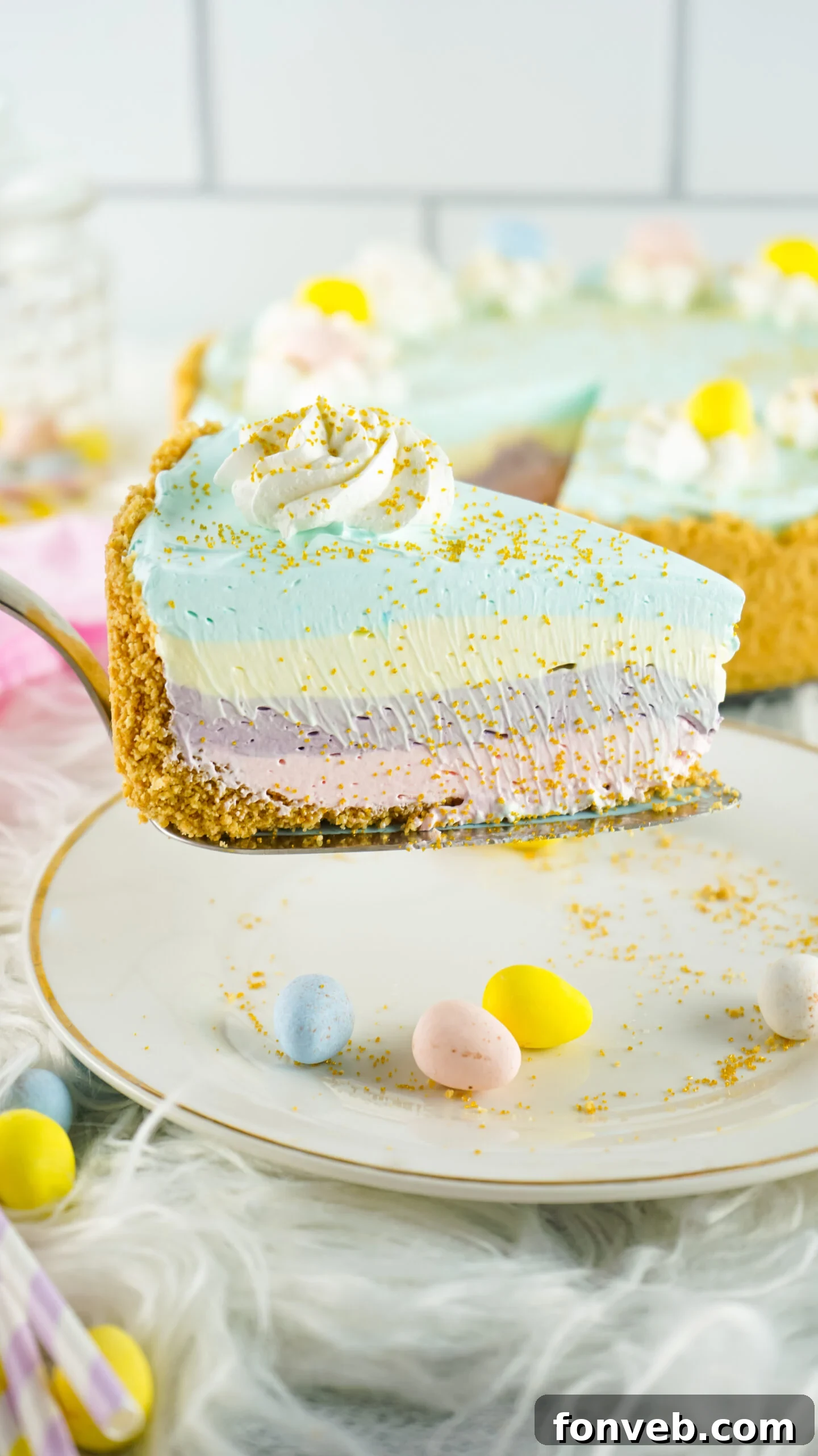 Zesty Easter Kool-Aid Pie 2 Side view of a perfectly sliced Easter Kool Aid Pie on a elegant gold cake server, showcasing its vibrant, distinct layers.