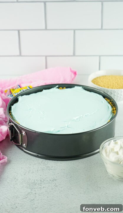 Zesty Easter Kool-Aid Pie 13 The final blue Kool-Aid layer being smoothed over the yellow layer in the springform pan, completing the pie.