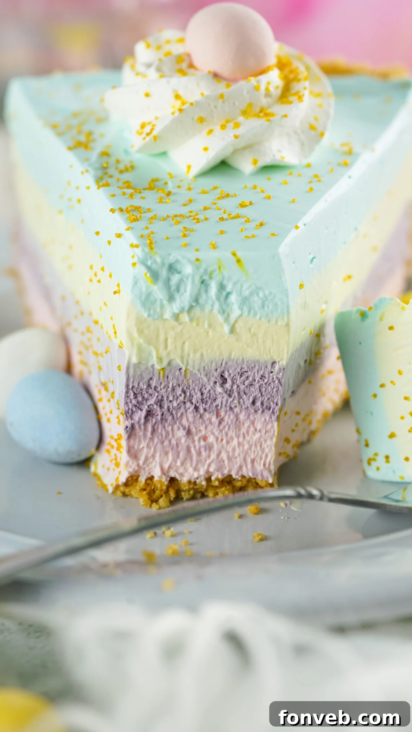 Zesty Easter Kool-Aid Pie 18 Front view of a whole Easter Kool Aid Pie with a silver fork removing a bite from a slice, showing the vibrant layers and smooth texture.