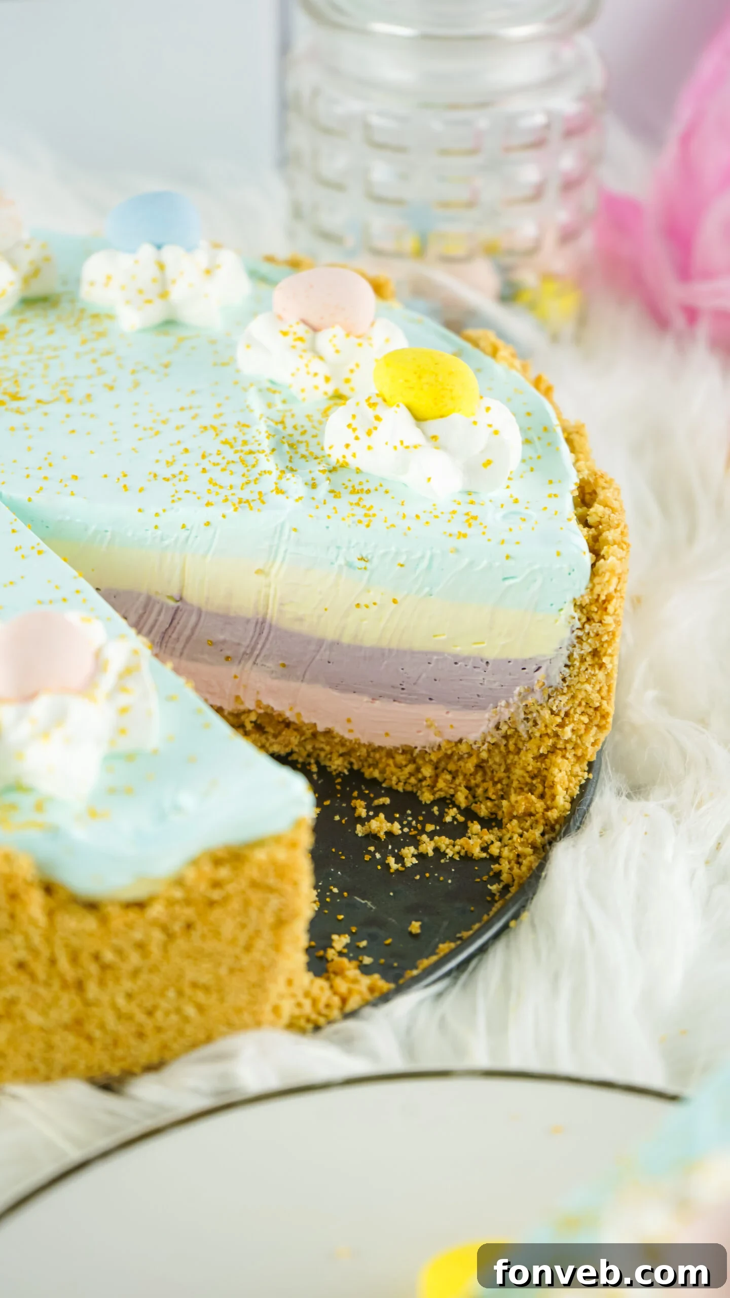 Zesty Easter Kool-Aid Pie 5 Close-up overhead view of a colorful Easter Kool Aid Pie with one slice removed, showcasing the vibrant layered interior.