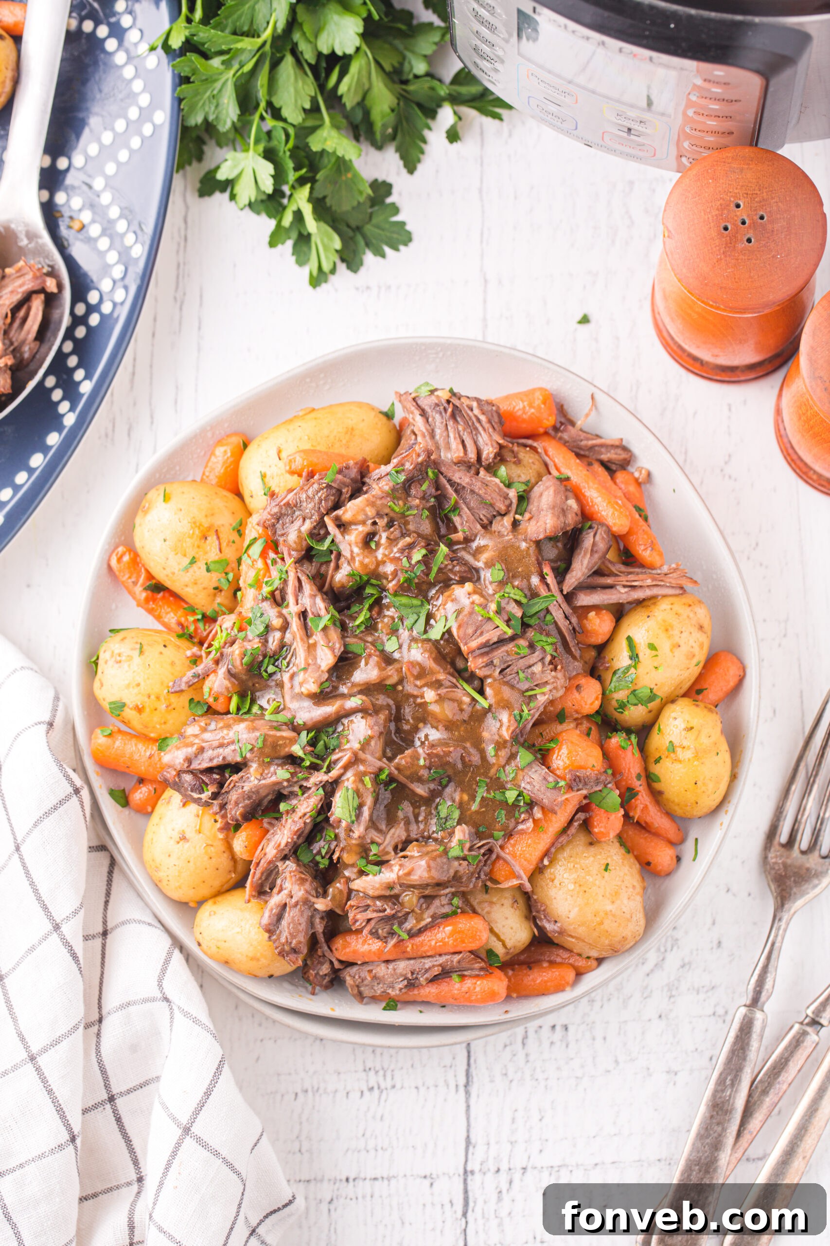 Melt-in-Your-Mouth Instant Pot Pot Roast 11 Overhead view of the Pot Roast with potatoes and carrots on a white plate.