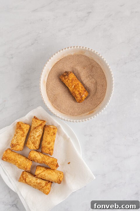 Image of several wrapped Cheesecake Egg Rolls on a plate before frying.