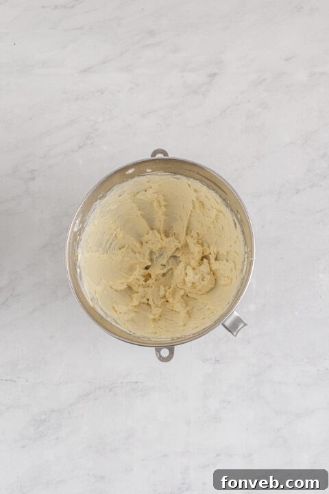 Step-by-step image of placing cream cheese filling onto an egg roll wrapper.