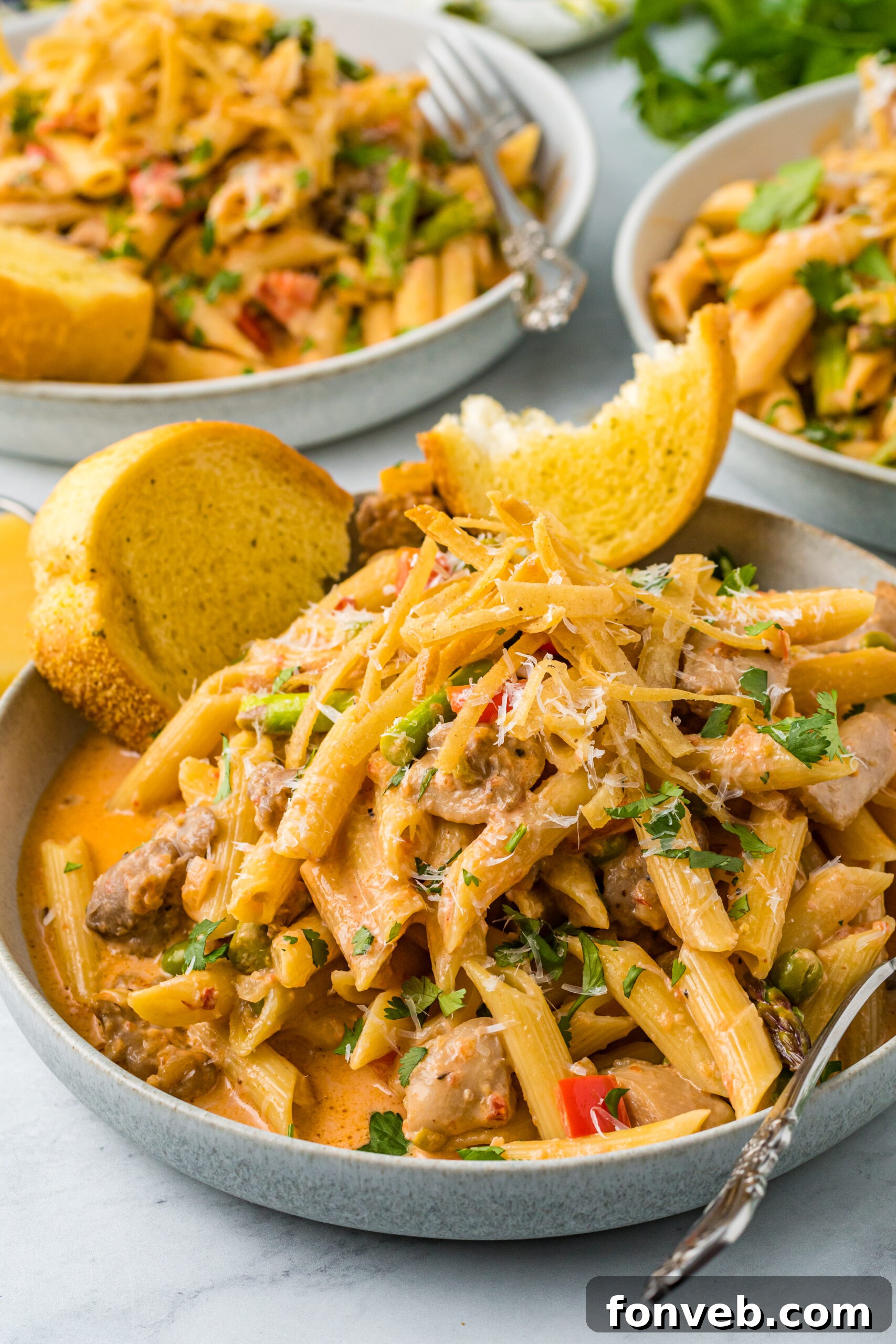 A vibrant dish of Creamy Cajun Chicken Pasta, garnished with fresh herbs, served alongside golden-brown garlic bread.
