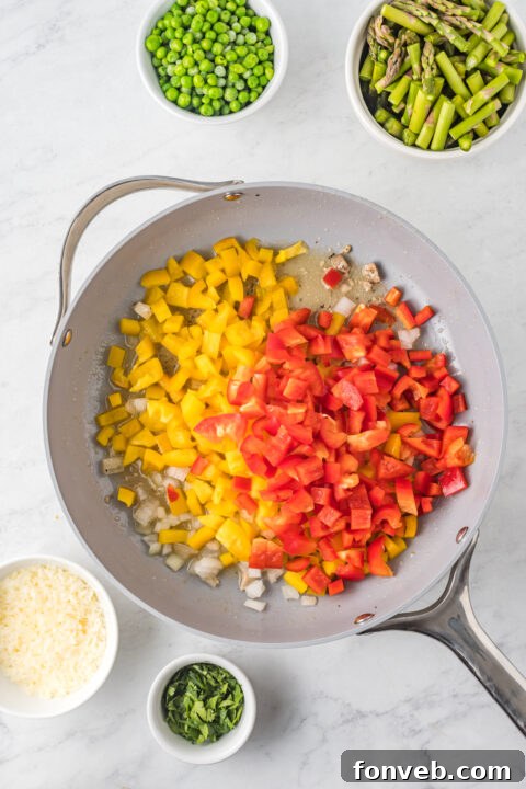 Preparation shot: Fresh asparagus and bell peppers being sautéed in a skillet.