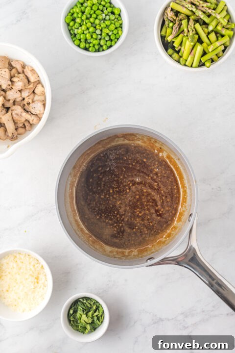 The creamy, spicy sauce being poured into the skillet with sautéed vegetables.