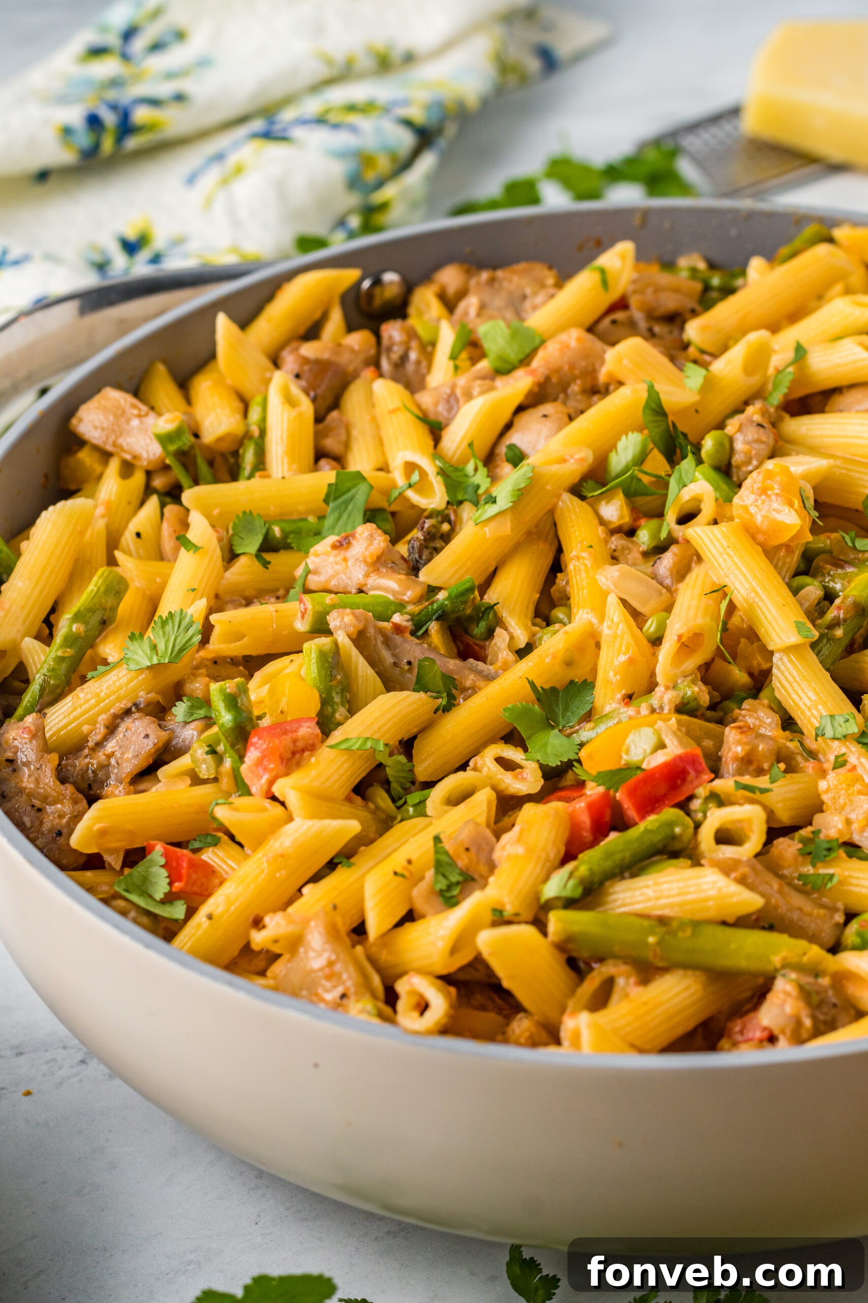 Side view of the spicy Cajun Chicken Pasta in a large frying pan, highlighting its texture and inviting colors.