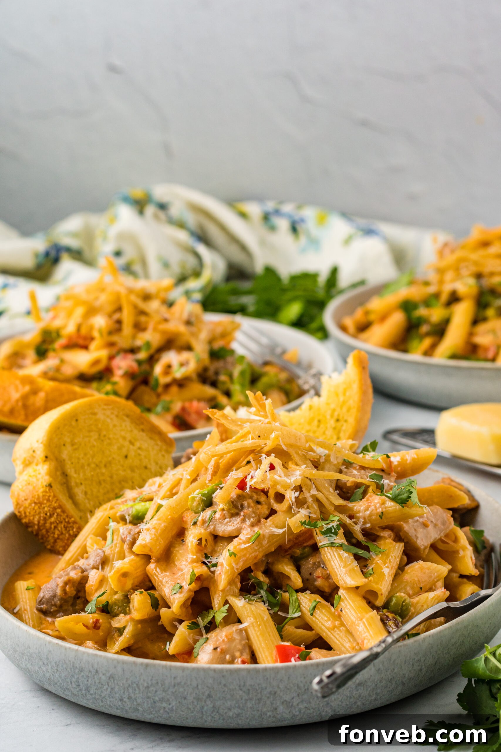 A serving of Cajun Chicken Pasta in a bowl, accompanied by golden garlic bread, ready to be enjoyed.