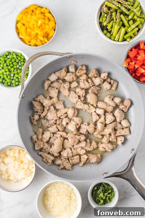 Close-up of golden-brown chicken pieces being seared in a hot pan.
