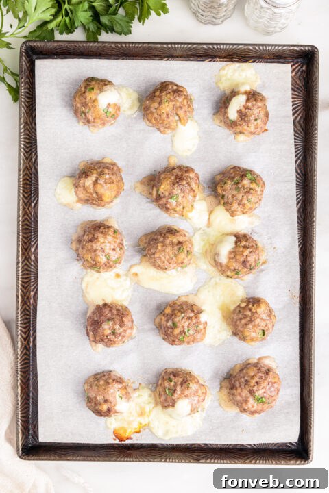 A close-up of baked mozzarella stuffed meatballs, golden brown and ready to serve.