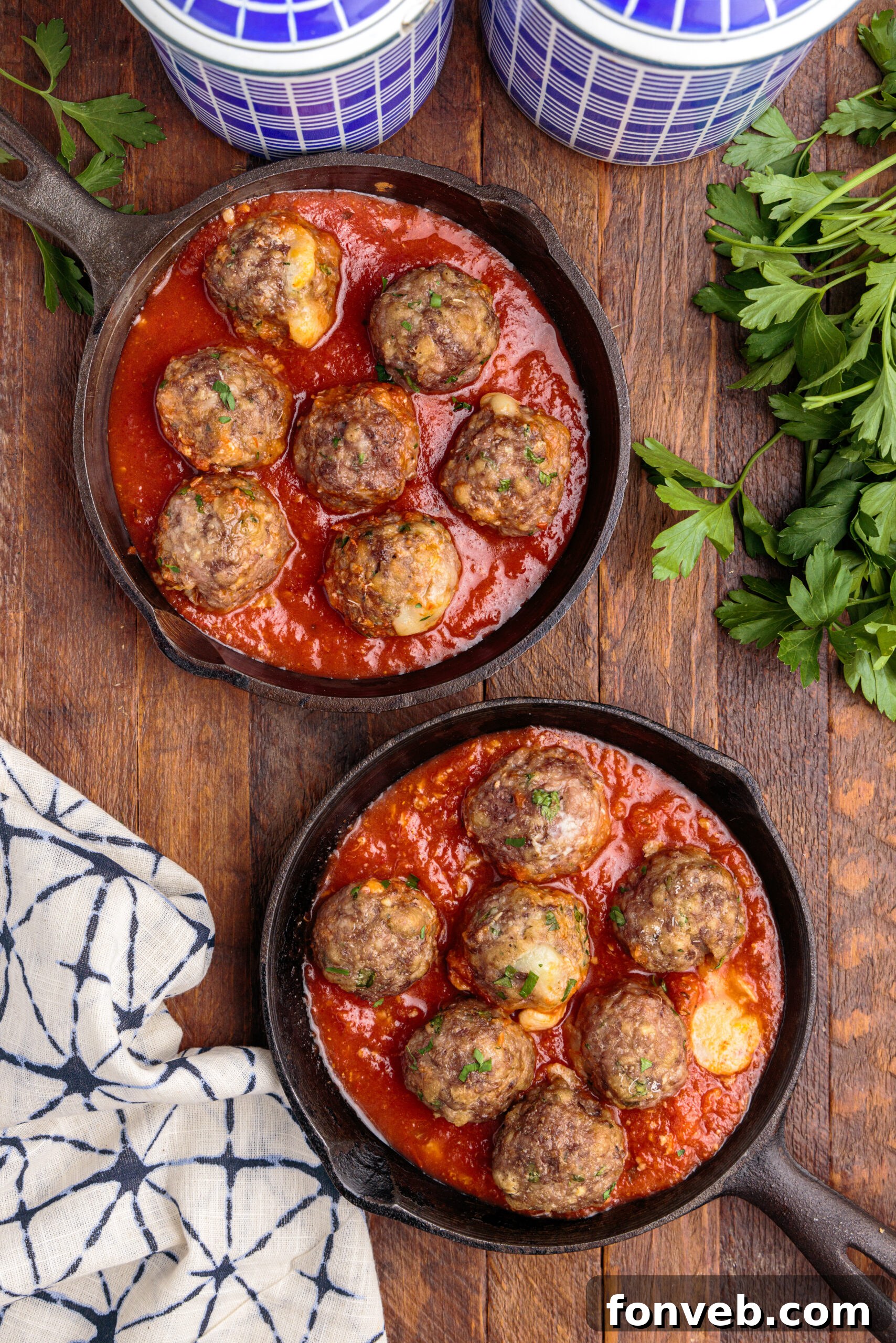 Overhead view of perfectly browned Mozzarella Stuffed Meatballs arranged in a rustic cast iron skillet.