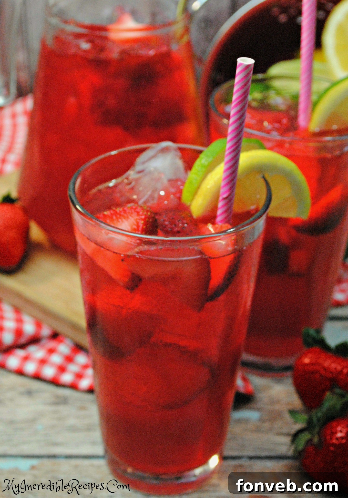 Fresh ingredients for Southern Strawberry Sweet Tea laid out: tea bags, sugar, strawberries, lemons, limes