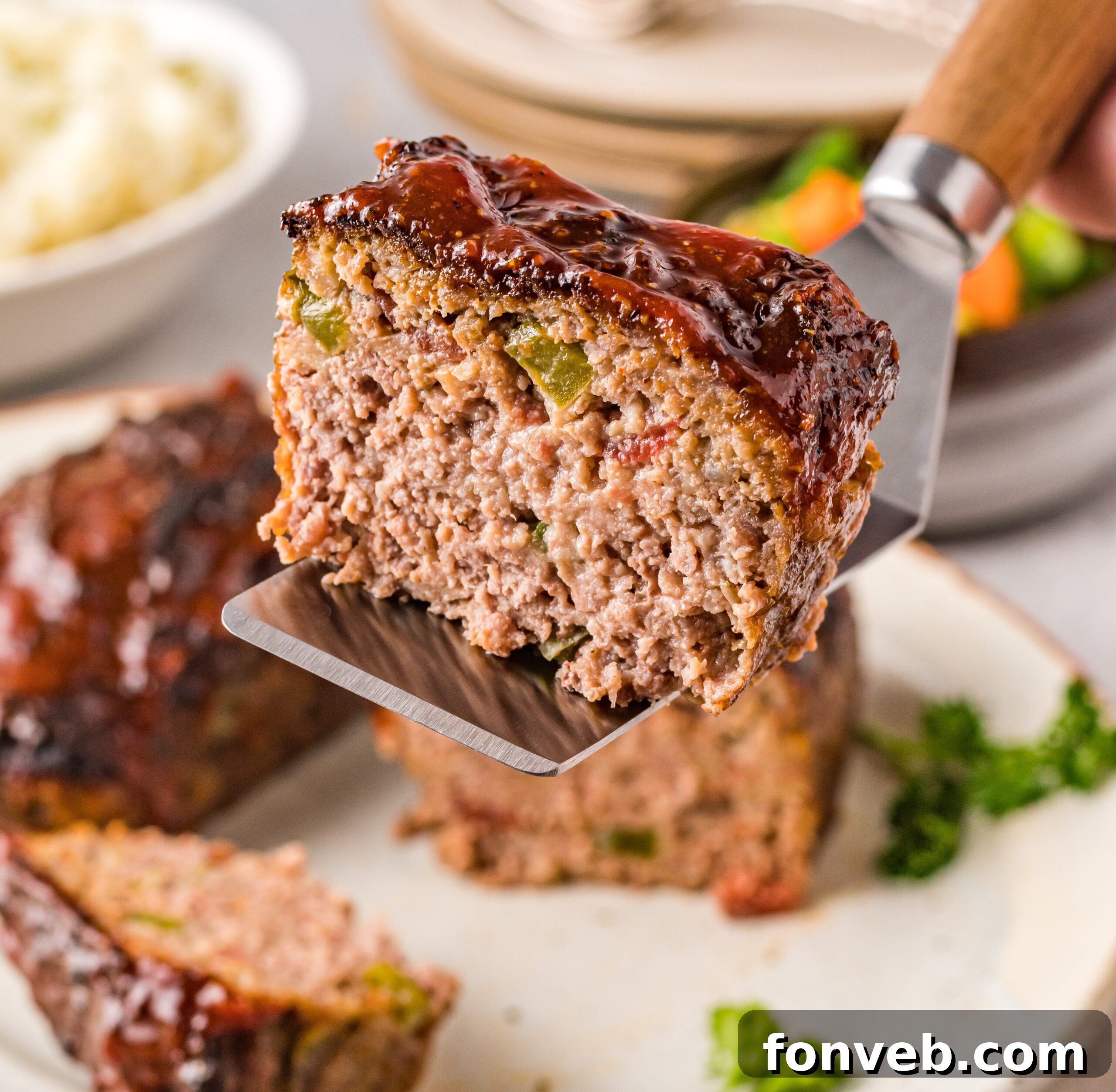 Cracker Barrel Meatloaf slice being held up on a spatula 