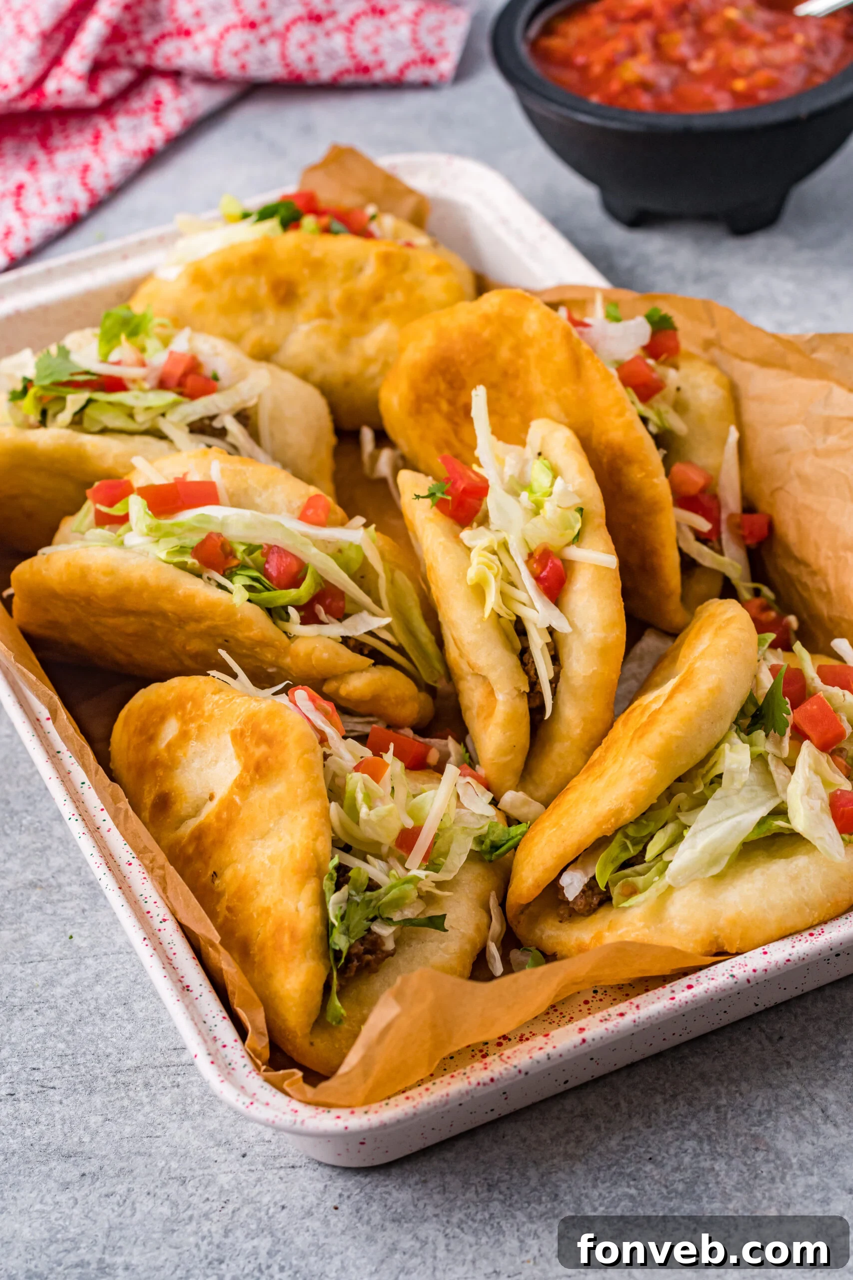 A vibrant close-up of a homemade Taco Bell Chalupa, showcasing the crispy golden shell, seasoned beef, fresh shredded lettuce, diced tomatoes, and a sprinkle of cheese, inviting a delicious bite.