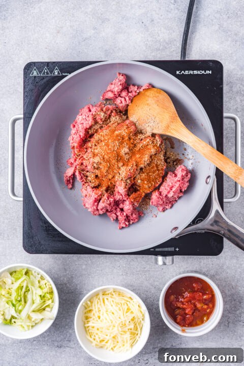 A chalupa shell being gently folded in half with tongs during the frying process.