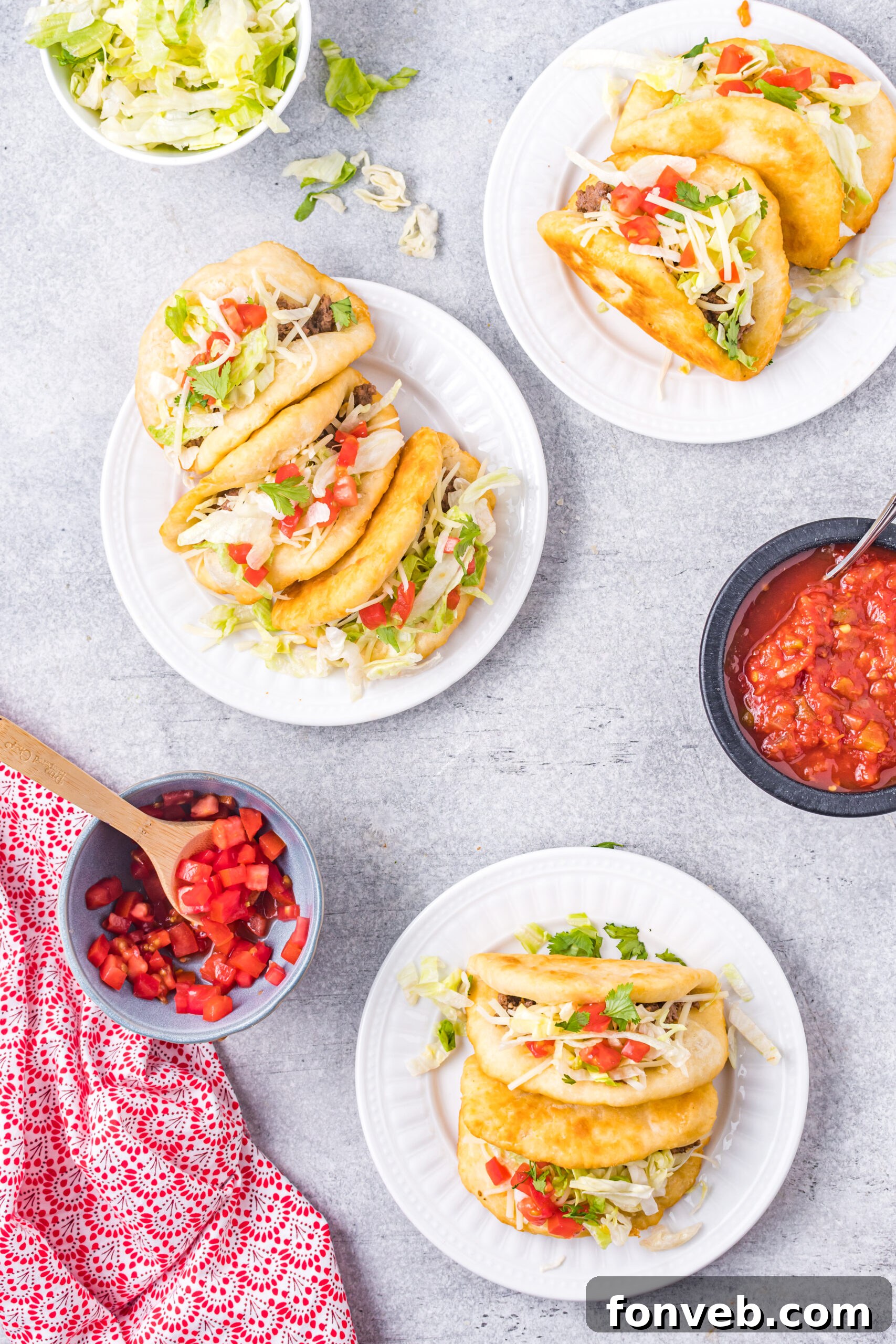An overhead shot of several perfectly assembled Taco Bell Chalupas arranged on white plates, highlighting the abundance of fresh toppings and the inviting texture of the fried shells.